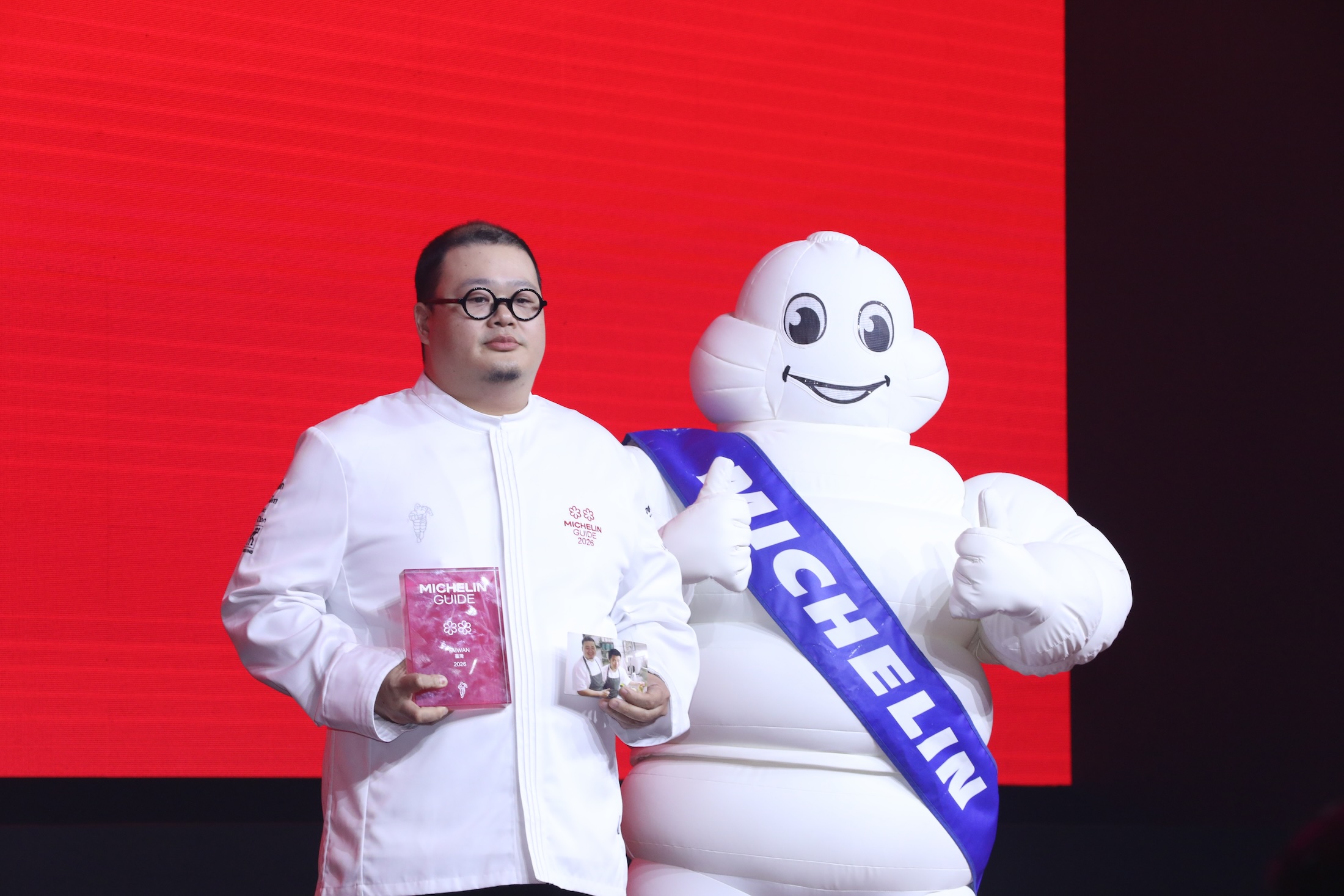 NOBUO餐廳從一星升上二星餐廳，主廚李信男拿著與好友的合影上台致辭。