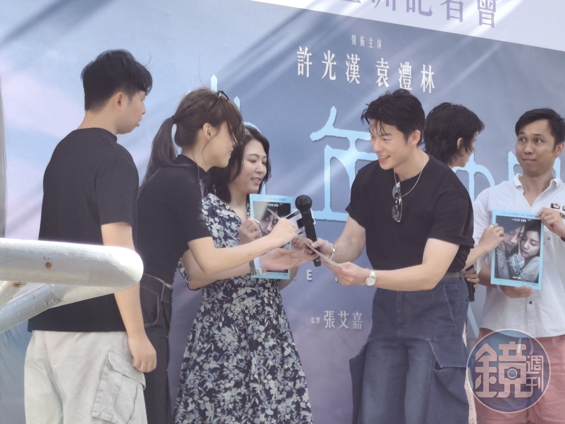 被抽中的幸運粉絲上台接受許光漢贈送的簽名海報。