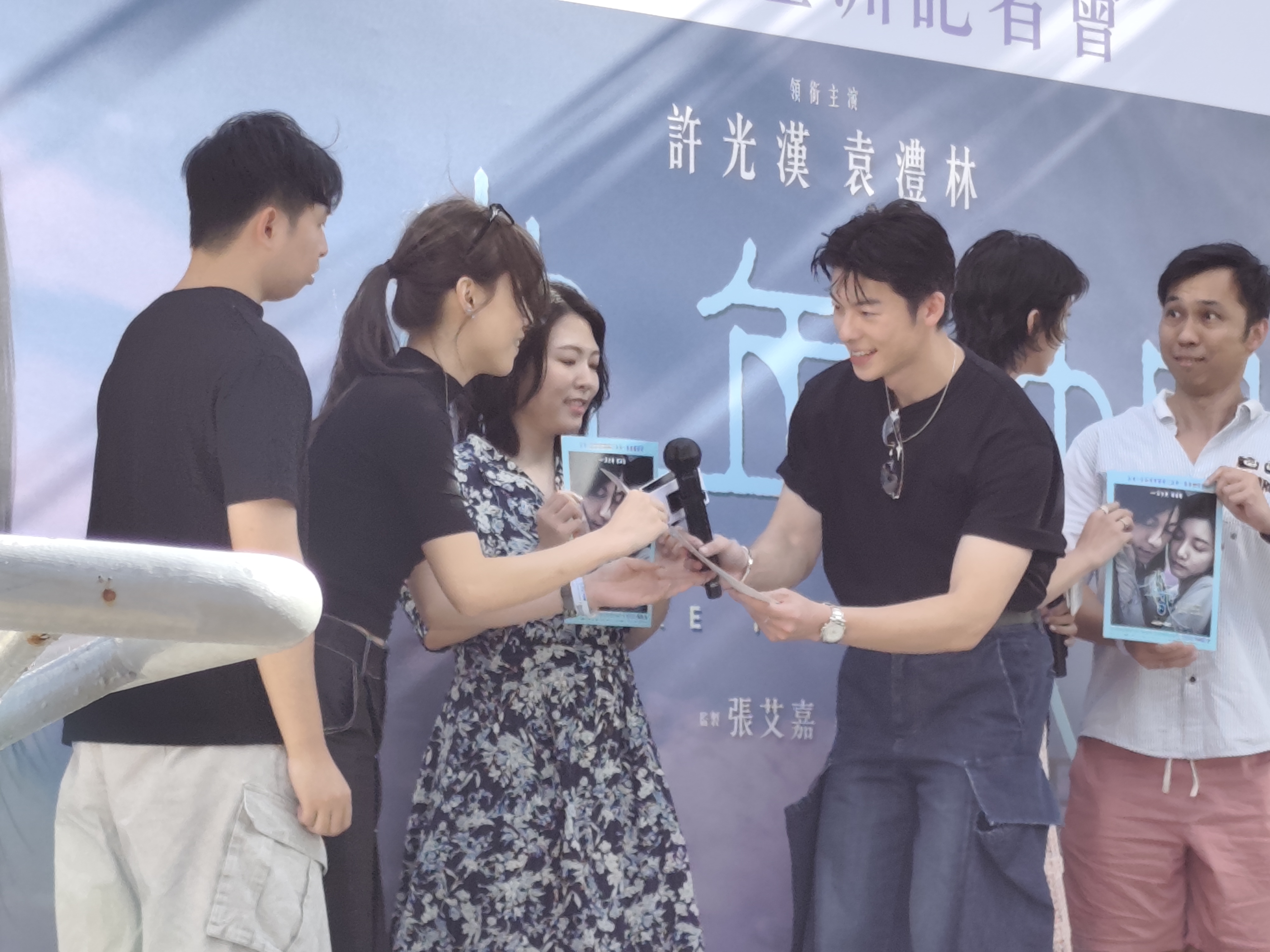 被抽中的幸運粉絲上台接受許光漢贈送的簽名海報。
