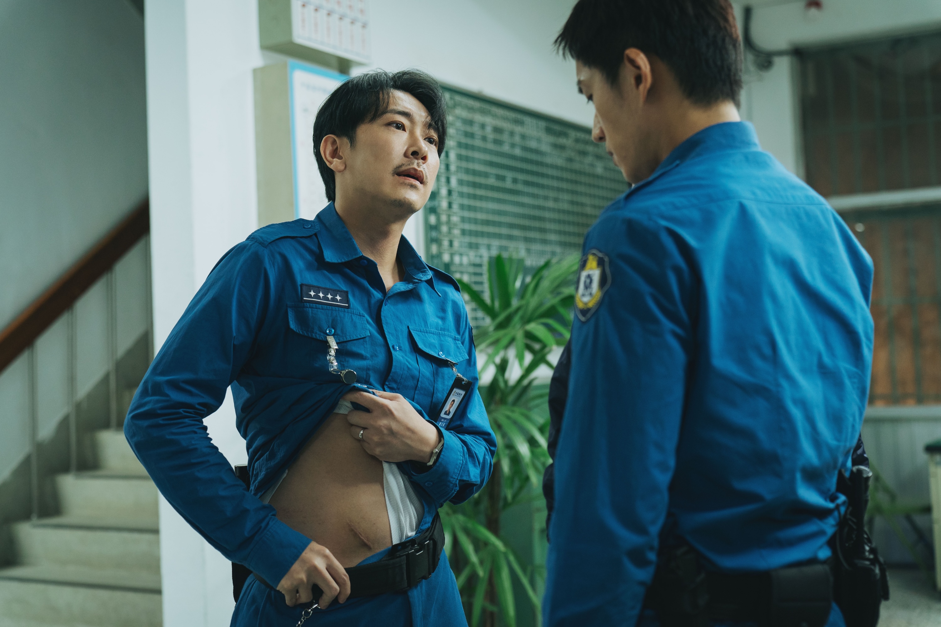 施名帥「震撼教育」,掀衣秀疤霸氣警告菜鳥。(愛奇藝國際版、壹壹影業提供)
