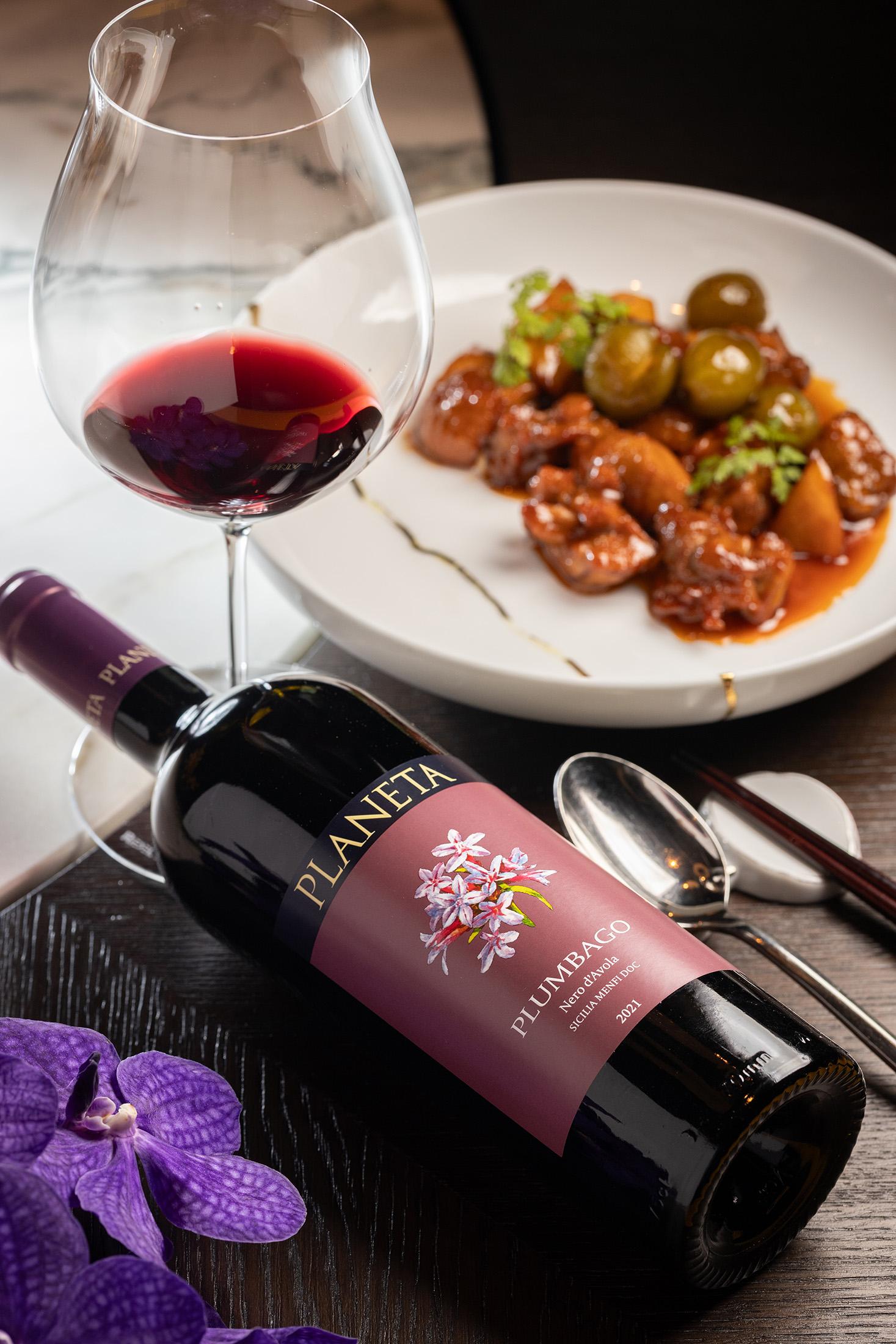 來自西西里島的紅酒「2021 Planeta Nero d'Avola」（2,100元／瓶）搭配「梅香燒嫩雞」（體驗式菜單菜色），用微煙燻感與果汁般的奔放果香，呼應雞肉的酸甜醬汁。