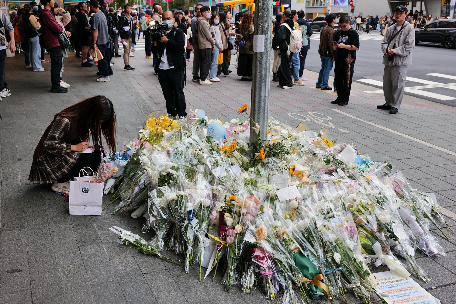 民眾在37歲蕭姓騎士遭砍倒下的地方獻花悼念。（攝影／杭大鵬）