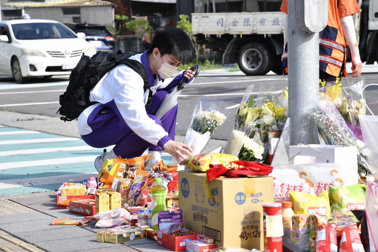 校門口成傷心地,有學生在上學前先送上鮮花悼念。(鏡報新聞網李智為攝)