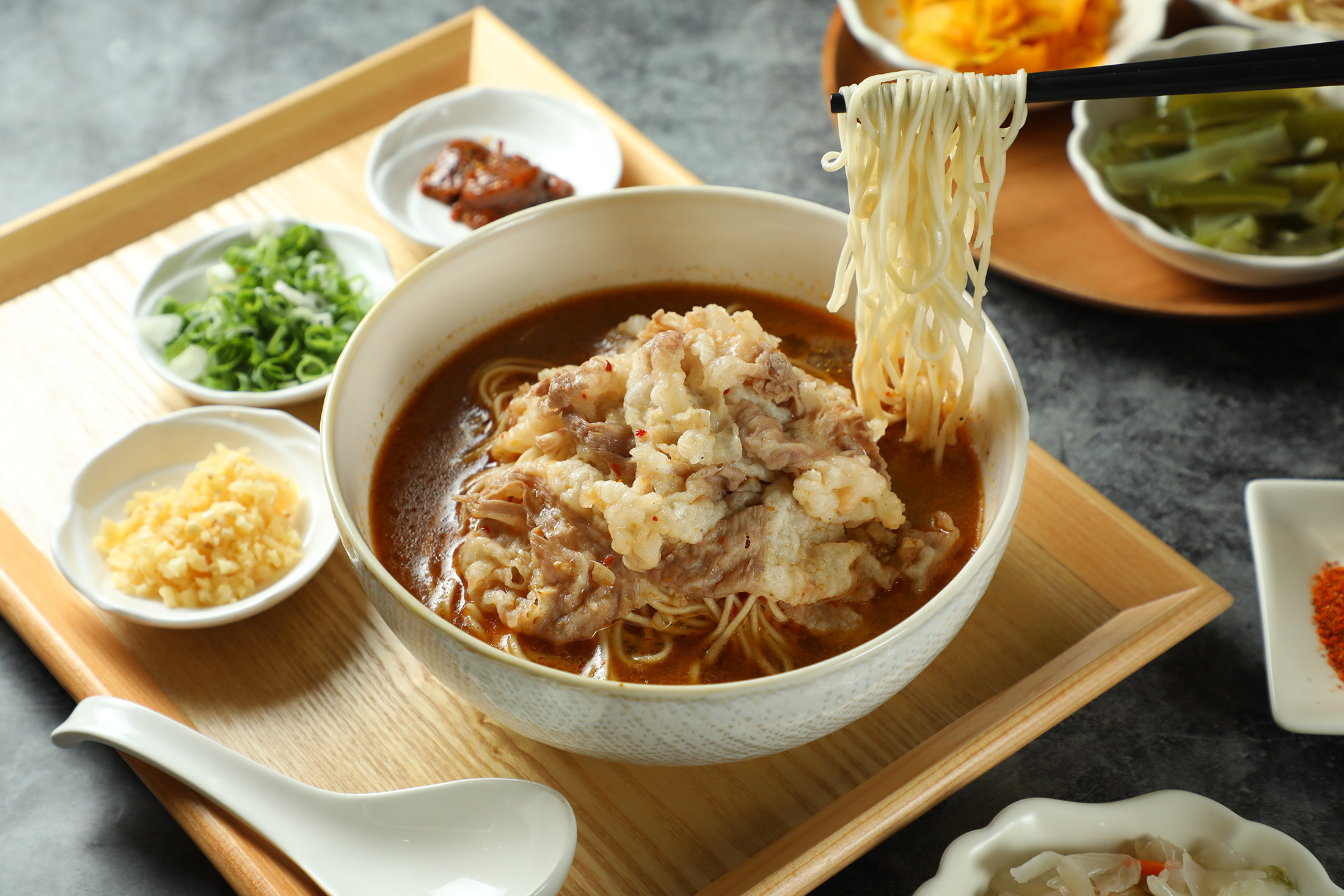 「神鬼干碟黃牛胸麵」以汆燙7至8分熟的金門黃牛胸腹肉片，搭配店家自製干碟粉，為紅燒湯頭注入鮮美風味。（480元／碗）