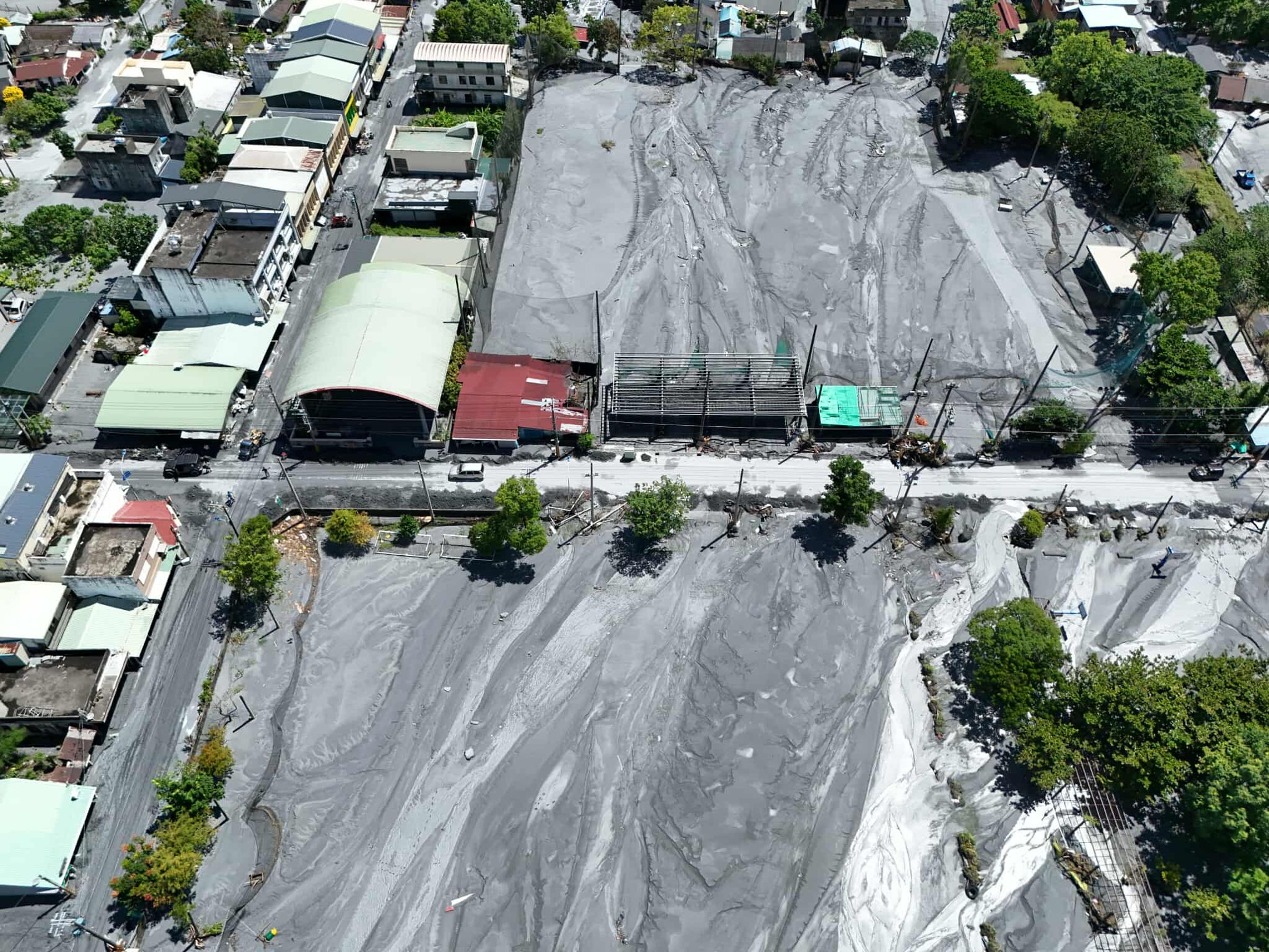 堰塞湖溢流後，花蓮縣光復鄉的道路與房屋都被淤泥覆蓋，居民正在努力重建家園。（花蓮縣社區大學空拍教師簡嘉信提供）