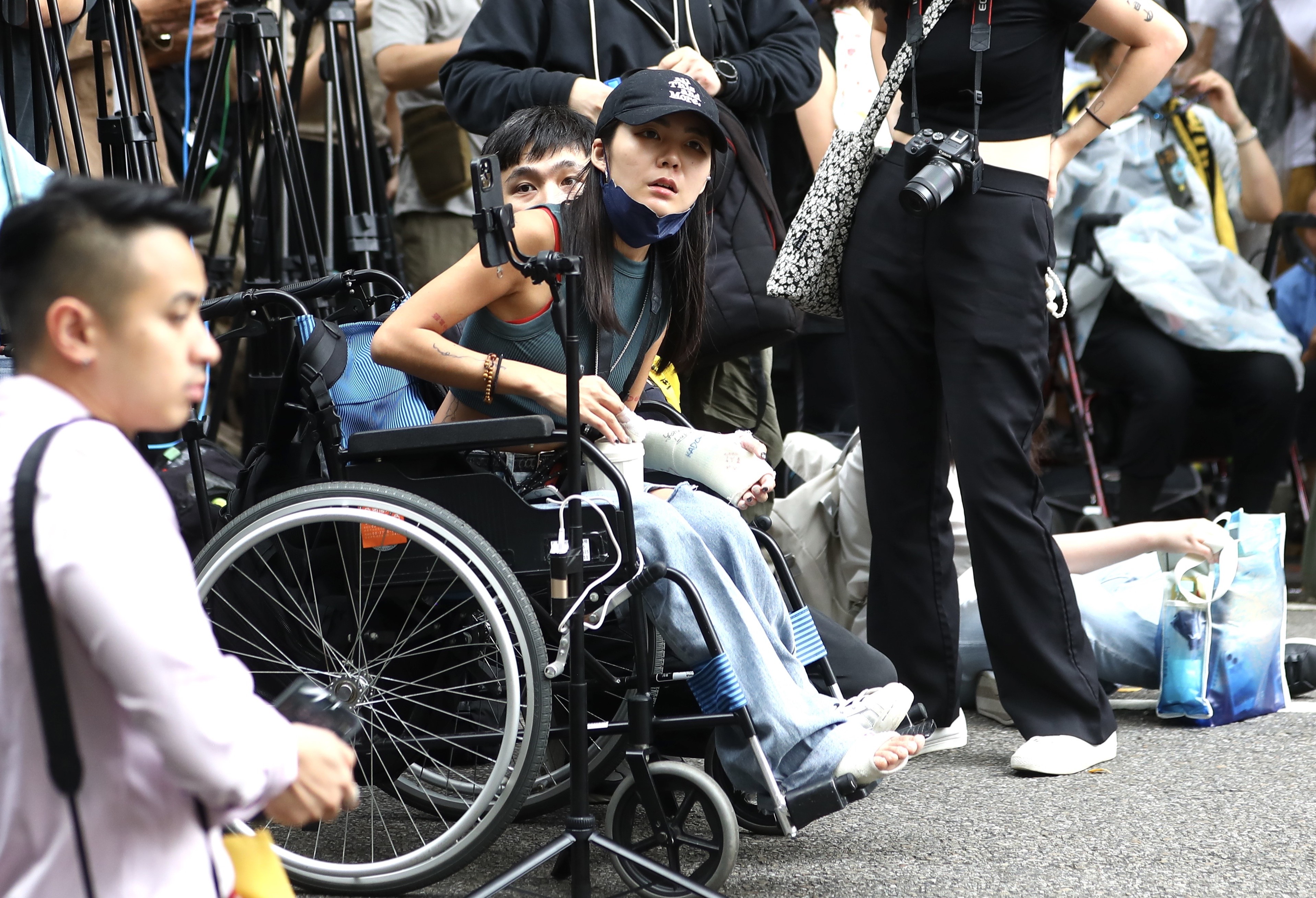 「輪椅妹」吳亭臻21日依然坐輪椅現身立法院外。