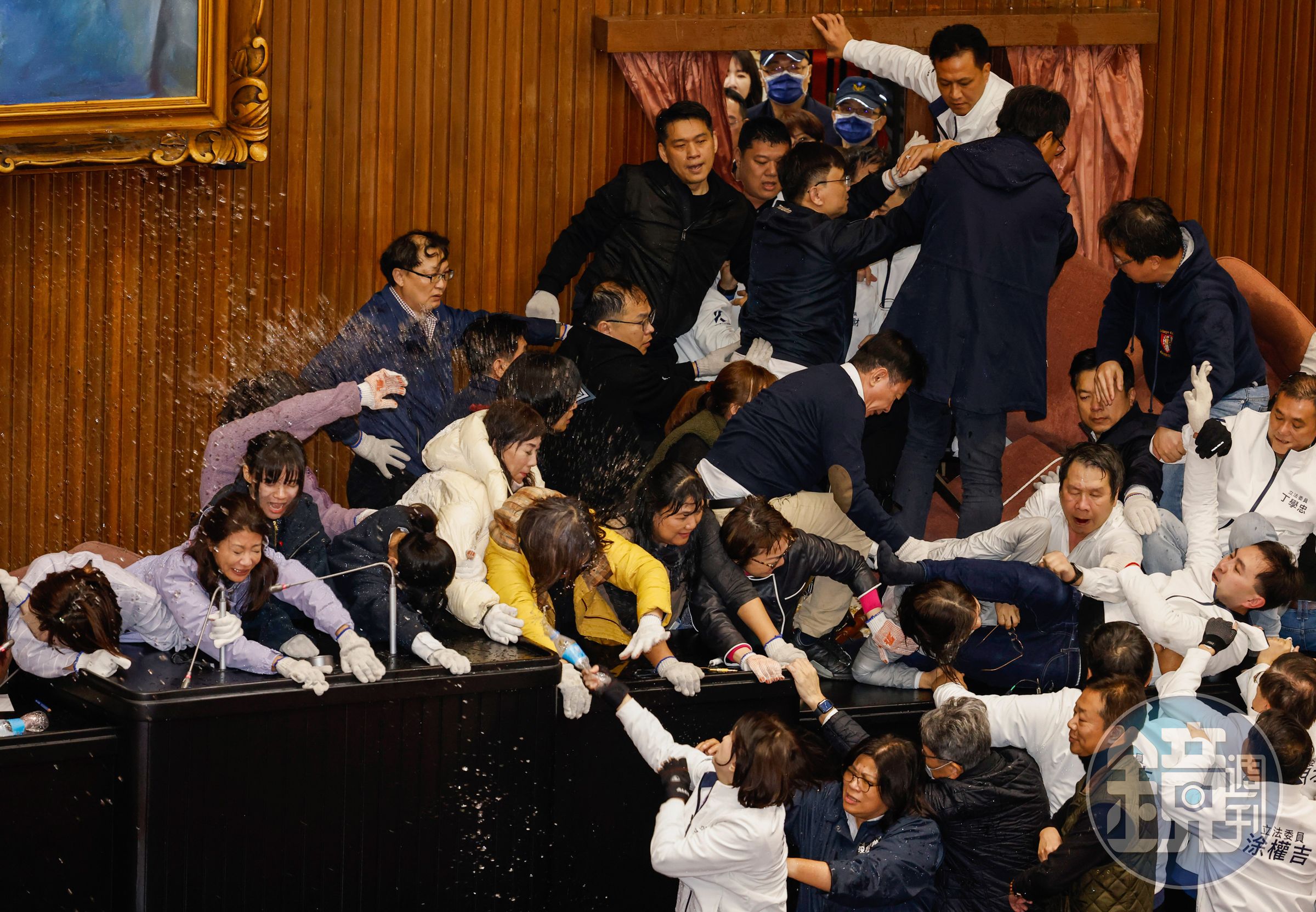 民進黨立委為阻止藍白聯手修選罷法佔領議場,國民黨立委破門攻入後,雙方在主席台上拉扯推擠,以腳夾頭與潑水等全武行大亂鬥。