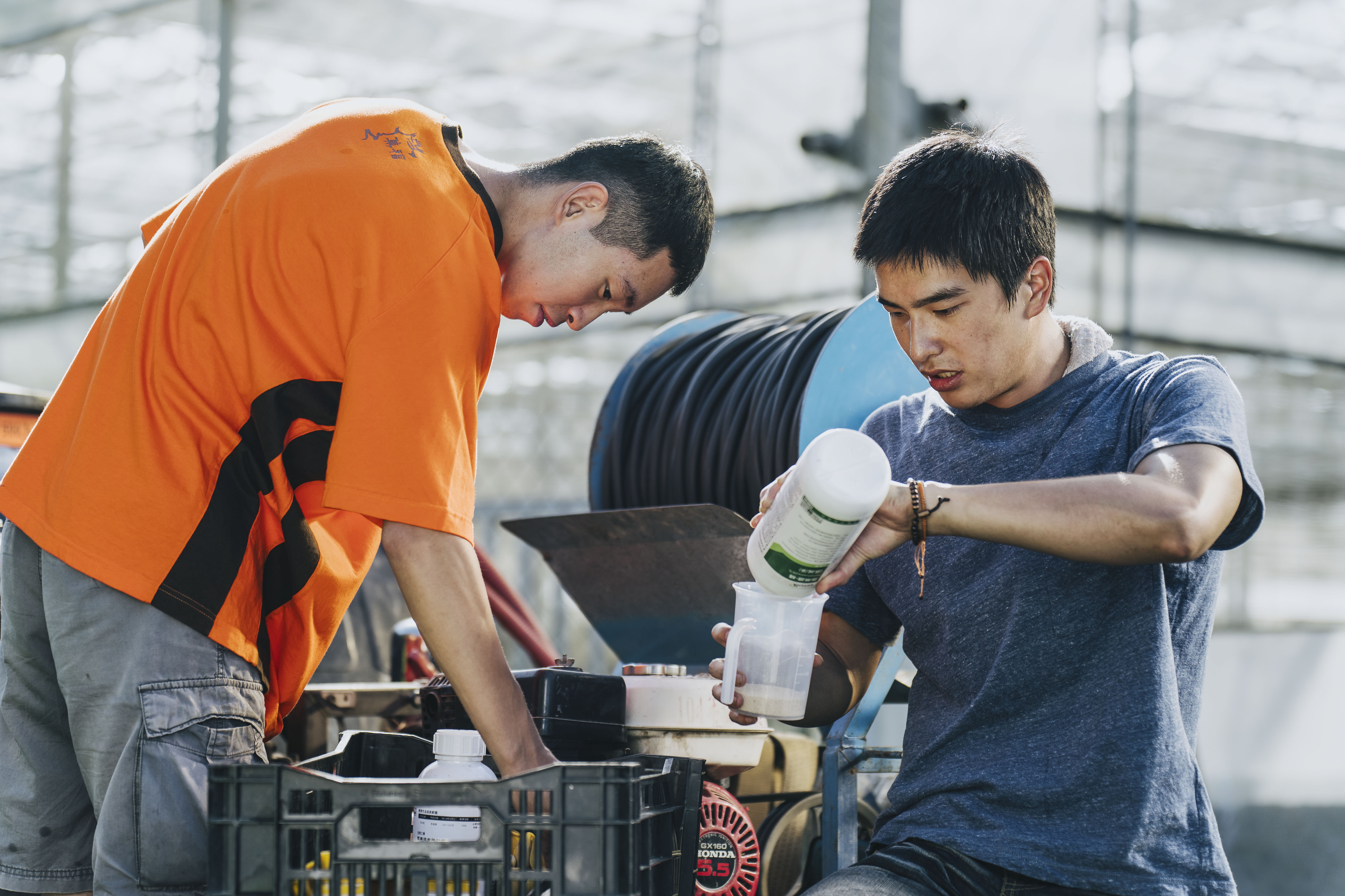 曾敬驊（右）為角色苦練農務並到工廠實習。（冬候鳥電影、文策院提供）
