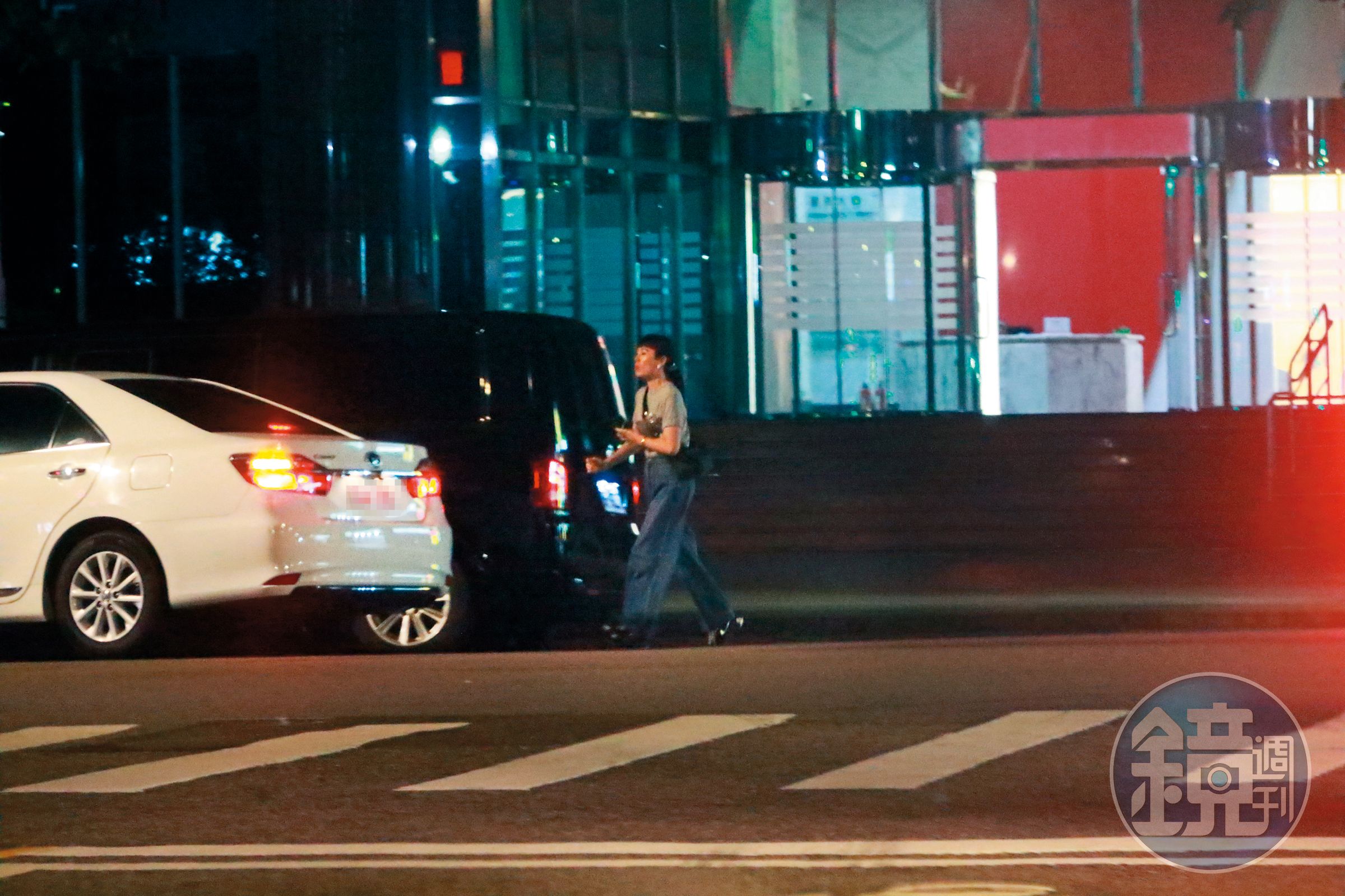 11/8，23：03魏如萱邊喝水邊在路邊耐心等待多元計程車到來，最後搭車回家。
