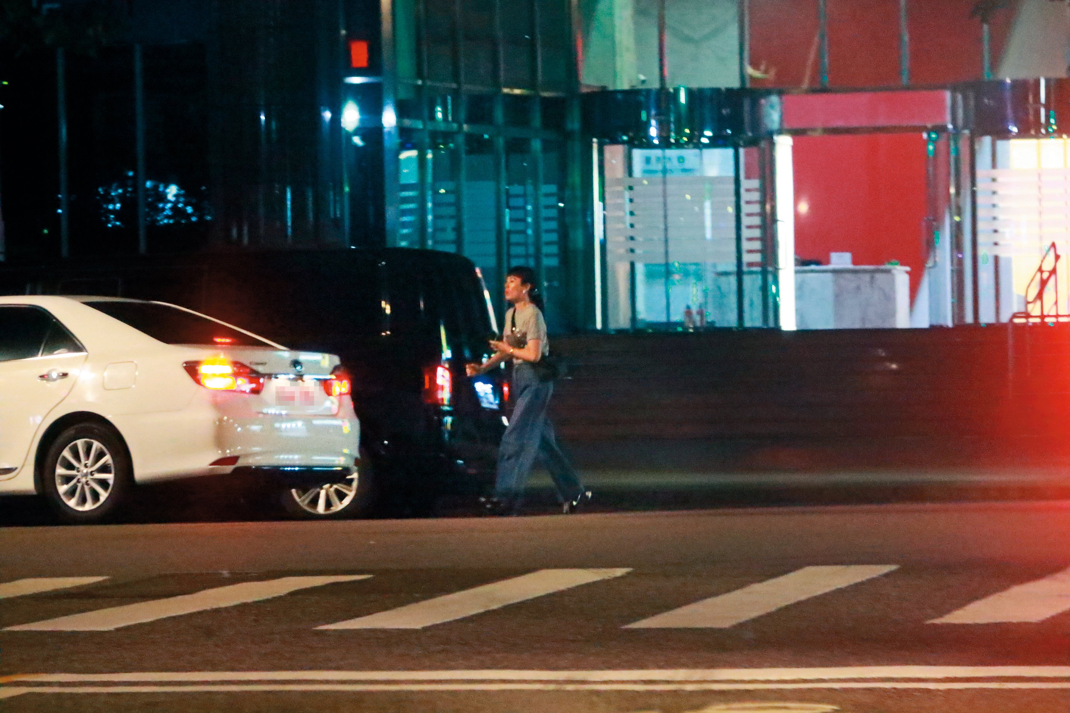 11/8，23：03魏如萱邊喝水邊在路邊耐心等待多元計程車到來，最後搭車回家