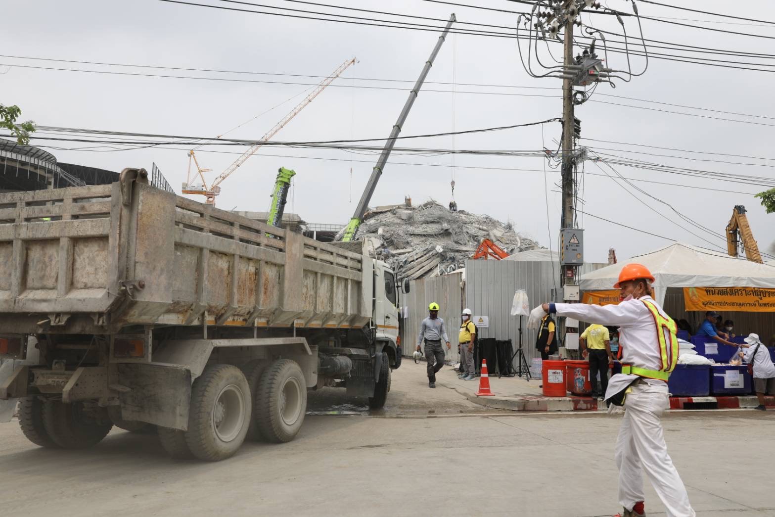 多部曳引車及大型重機具在塌樓現場進行清運開挖。