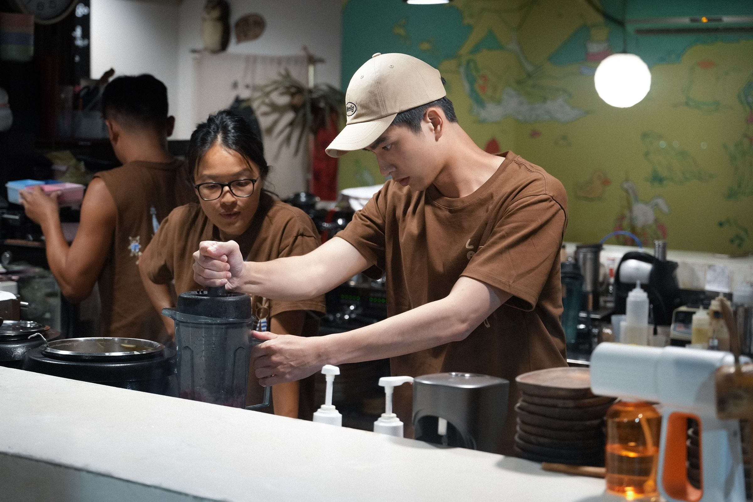 曾敬驊（右）在吳阿婆（左）蘭嶼餐廳打工，負責製作招牌冰沙。（公視提供）