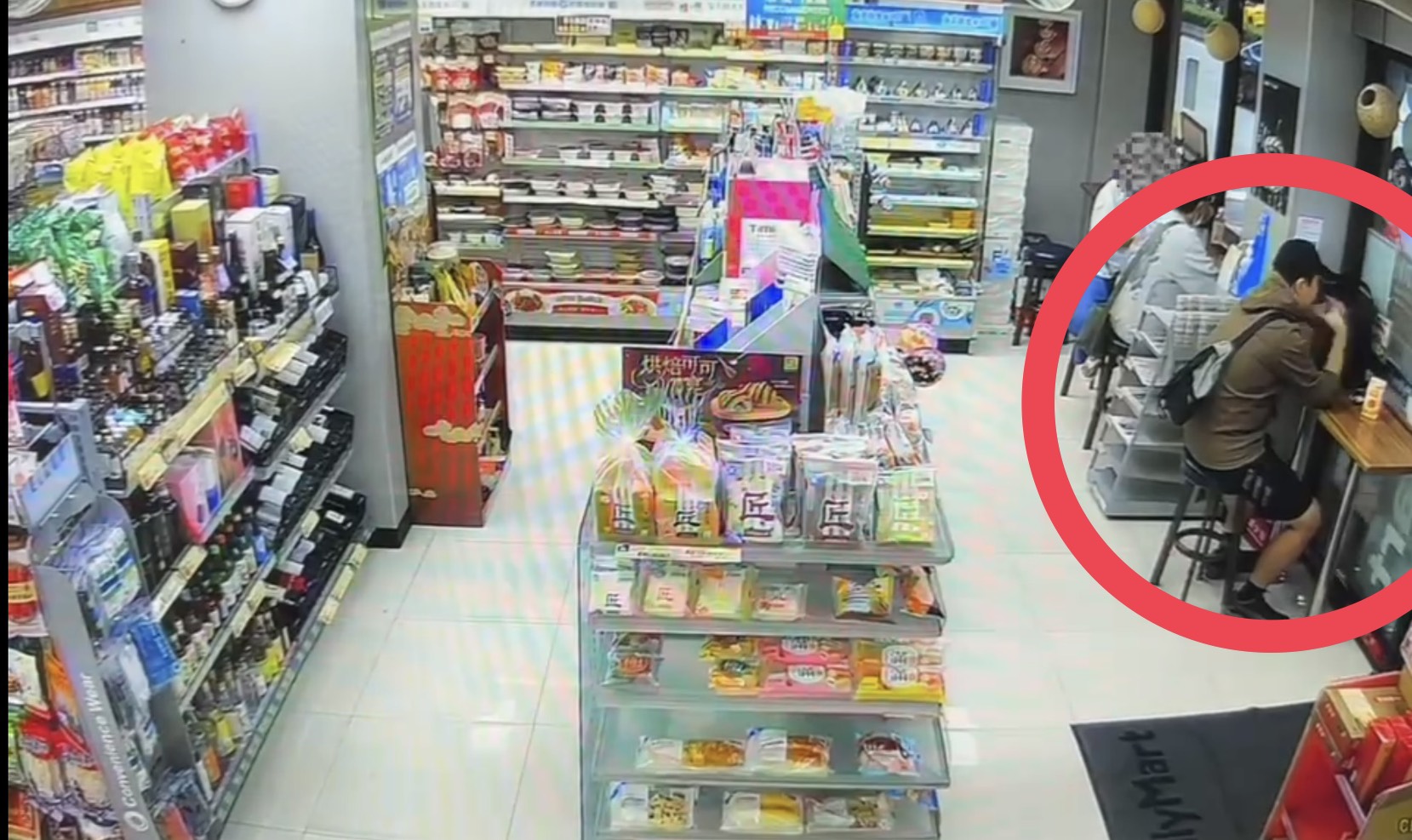 張文（紅圈）犯案前曾獨自到超商購物並一人枯坐在座位區，警方事後發現他刻意切斷與外界聯繫，屬孤狼式犯案。（翻攝畫面）
