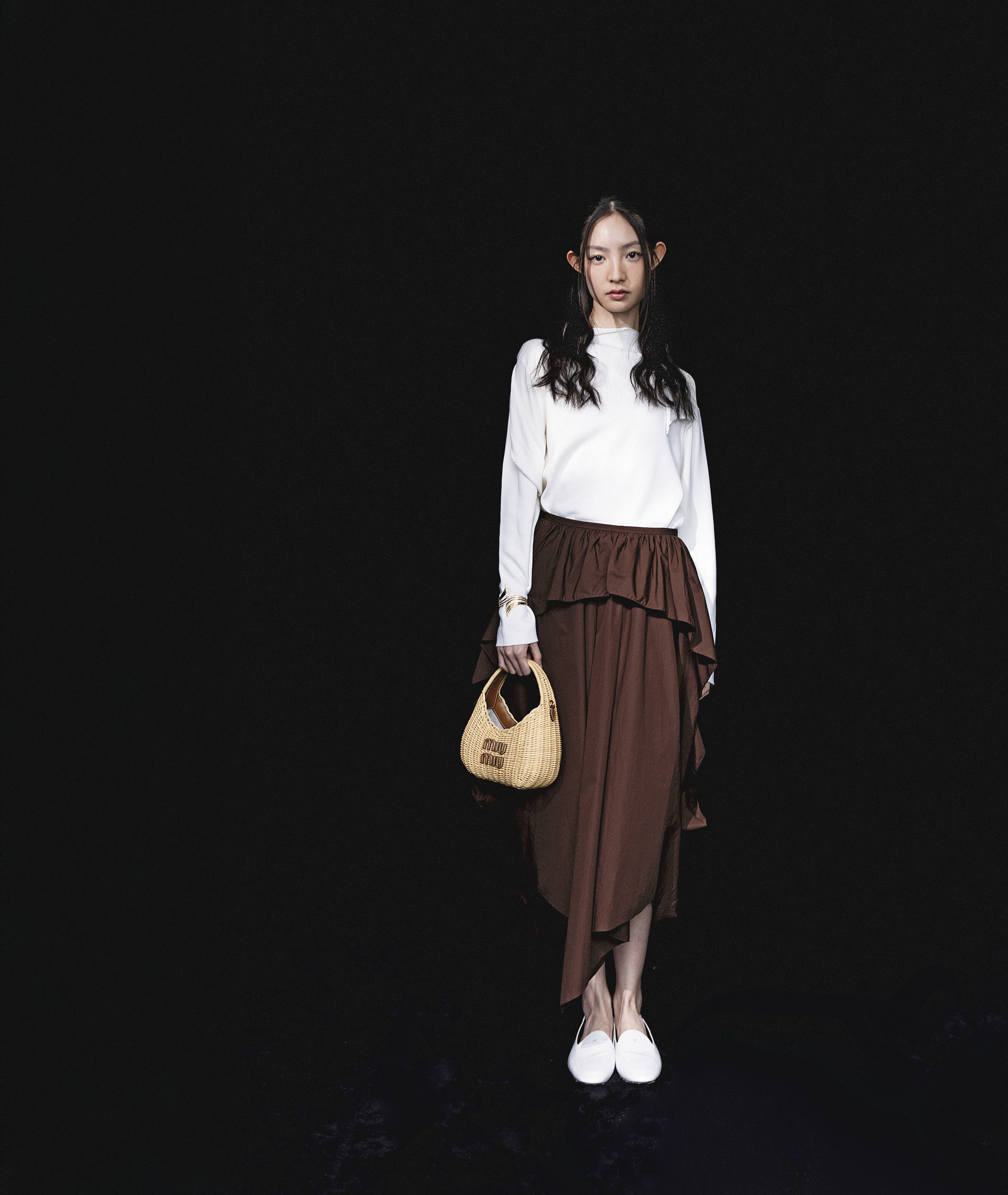 羊毛上衣 NT$49,000 by LOEWE；咖啡色棉質不規則長裙 NT$62,000 by LOEWE；AURA樂福鞋 NT$34,000 by CELINE；Les Palmes手鐲 NT$13,100 by APM MONACO；Wander竹編手提包 價格店洽 by MIU MIU