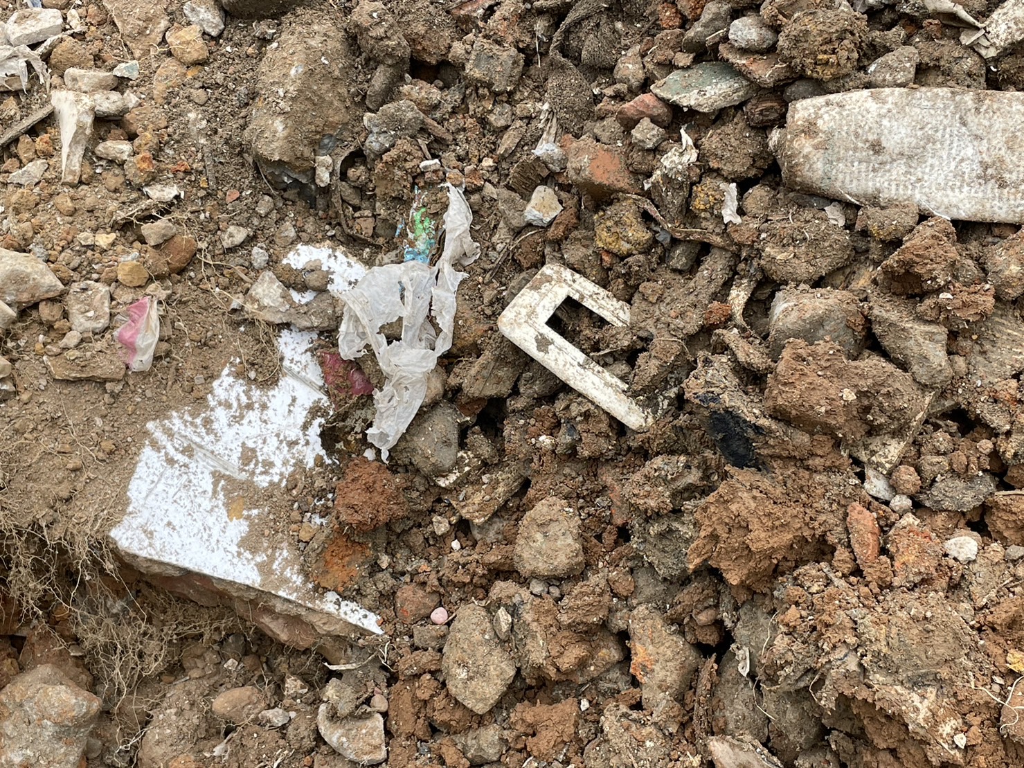 農地埋有垃圾、廢塑膠、廢鋼筋、鐵條、木材等大量營建廢棄物。(警方提供)