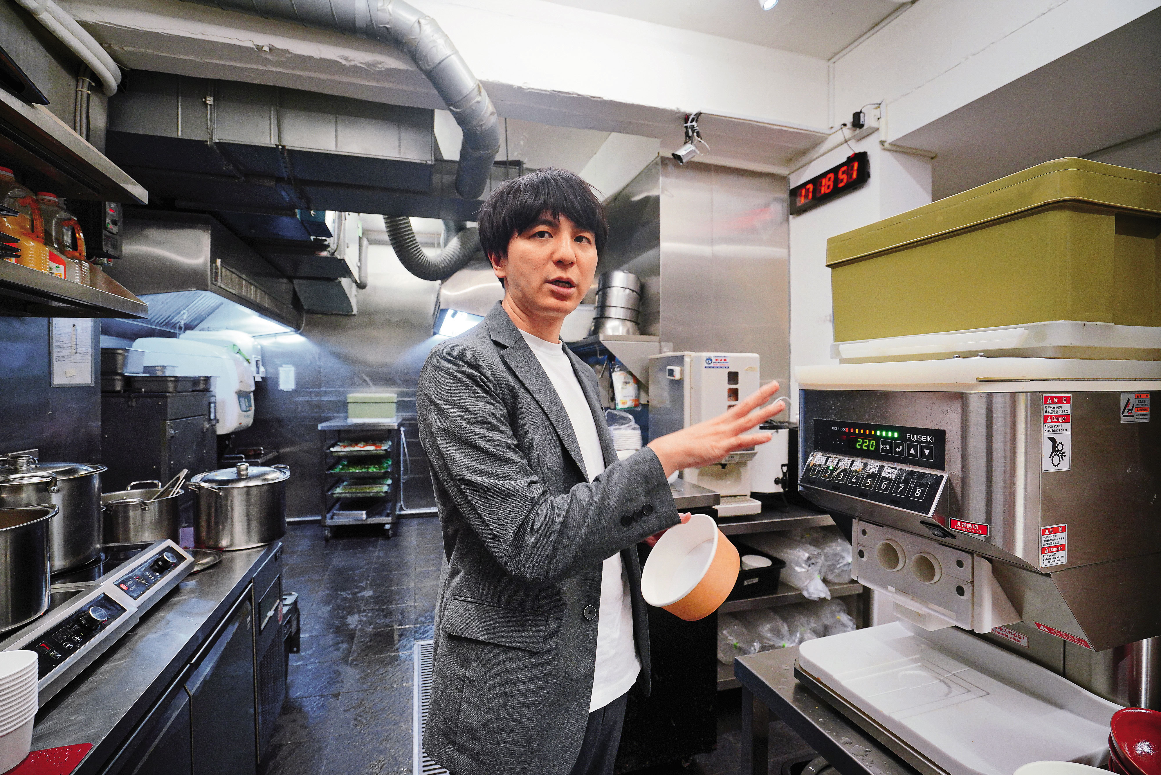 黃郁傑引進日式連鎖店的模式，為母親的3間店配備現代化設備，圖中的盛飯機，可精準控制每碗飯的重量。