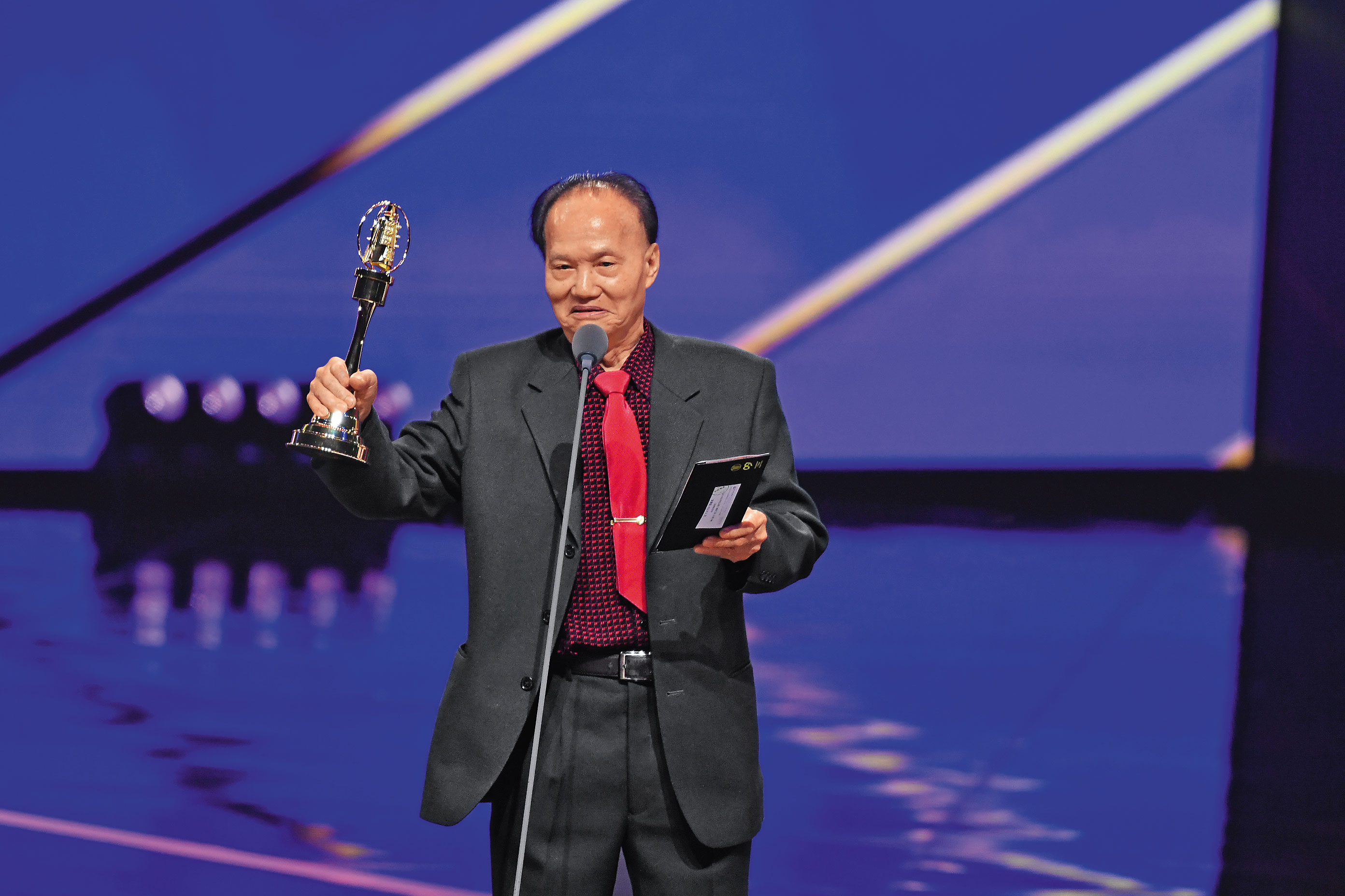 金鐘60頒獎典禮上，葉輝龍發表感言時舉起獎盃，眼眶一度泛紅。（三立提供）