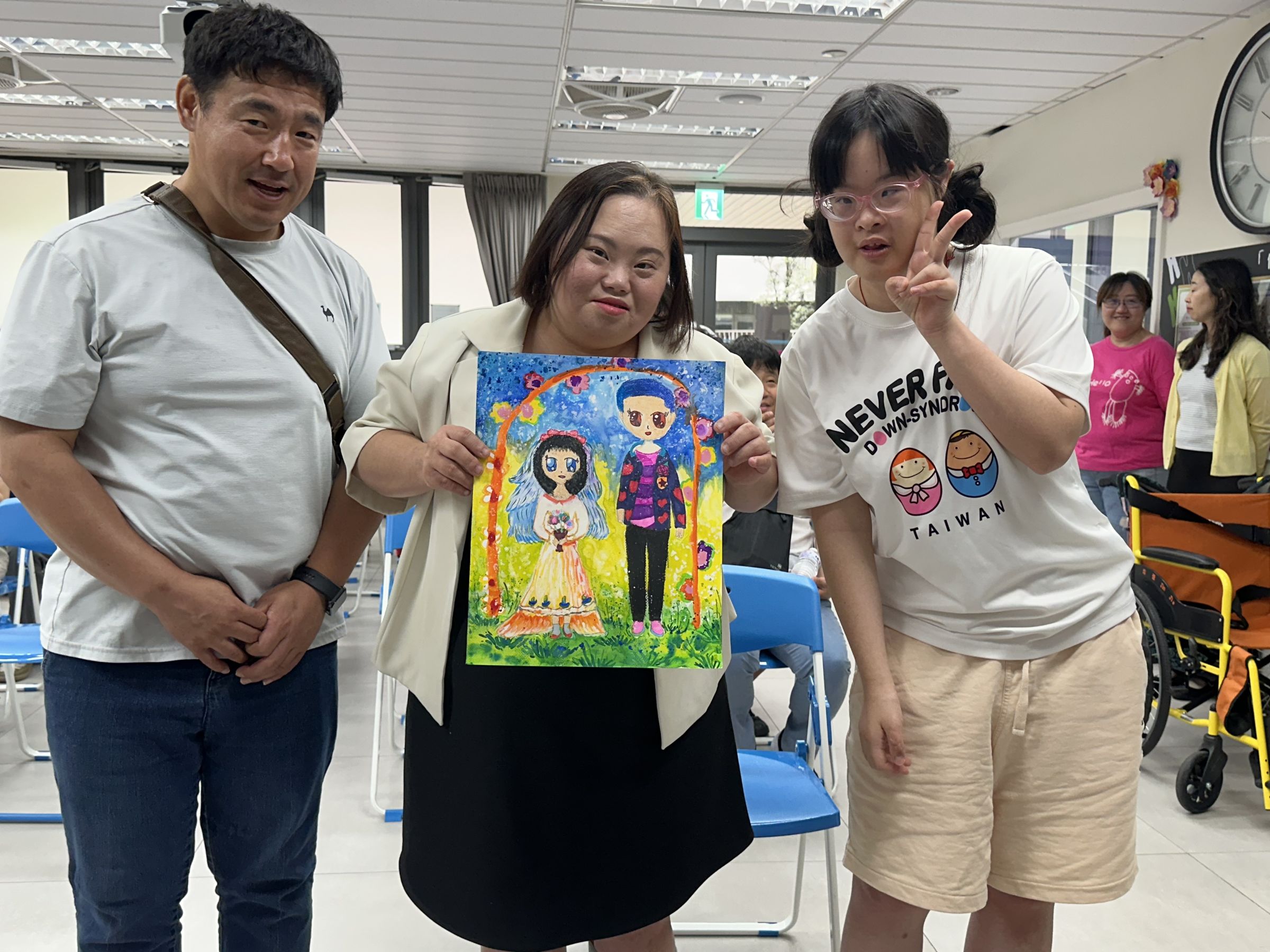 唐寶寶獻上親筆畫作，祝福鄭恩惠夫婦新婚幸福。（唐氏症基金會提供）
