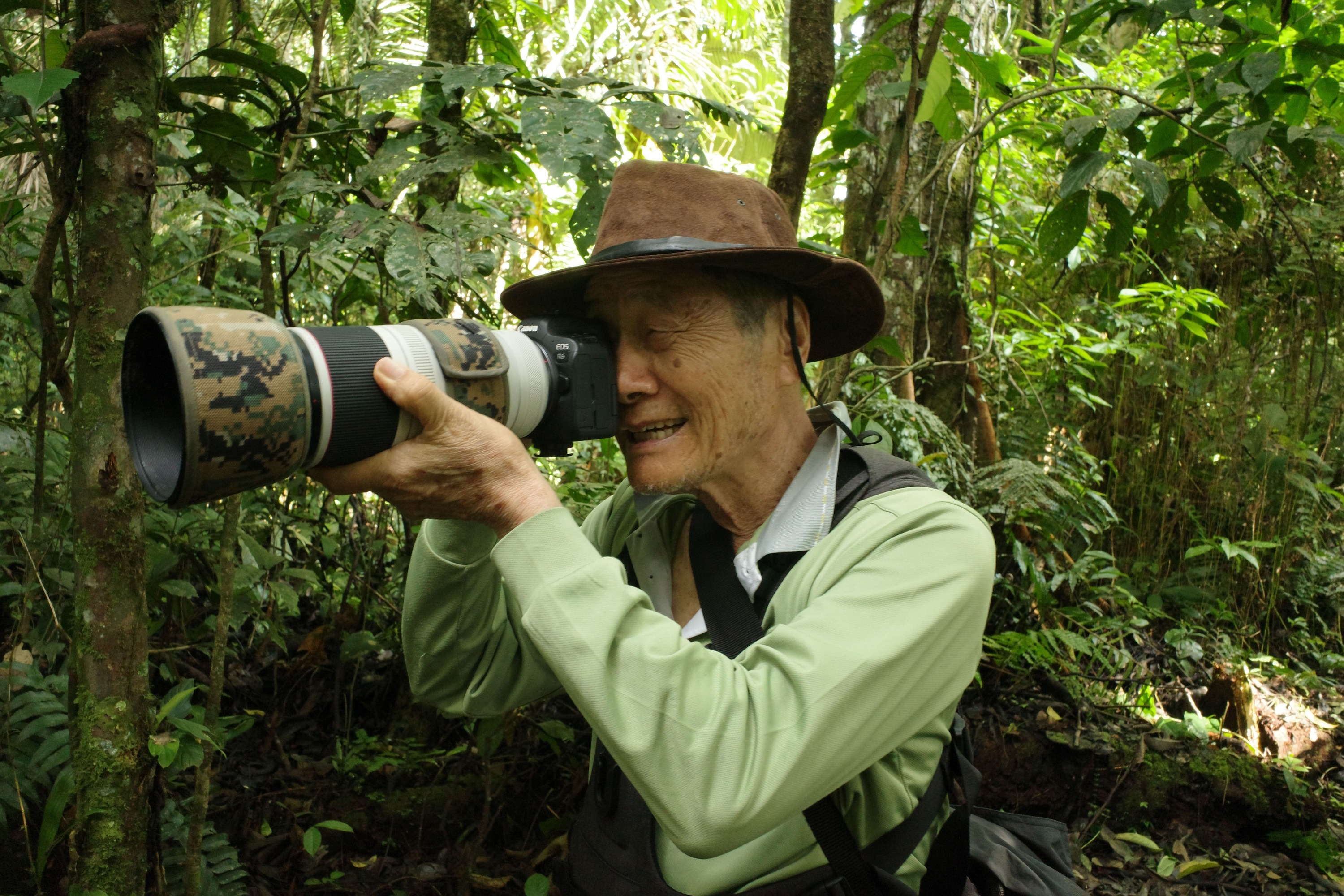 徐仁修拿著相機深入雨林，臉上滿是喜悅。（牽猴子提供）