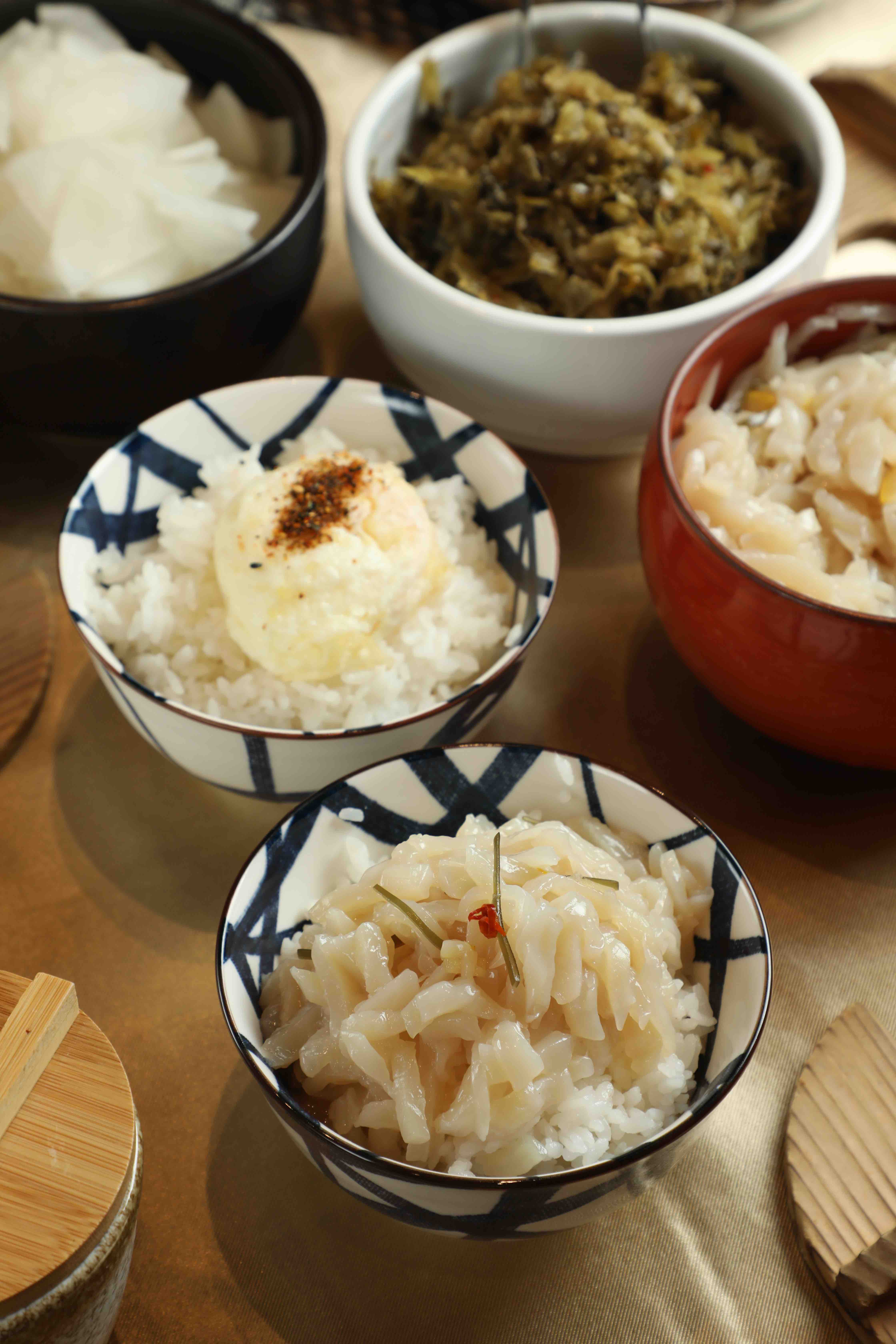 日本網友開發出隱藏吃法,將免費漬物「柚香魷魚」(前)鋪滿白飯變身迷你海鮮丼;或者加點「半熟玉子」(後,49元/個),劃破蛋黃、淋上特製醬油與黑七味粉拌著吃。