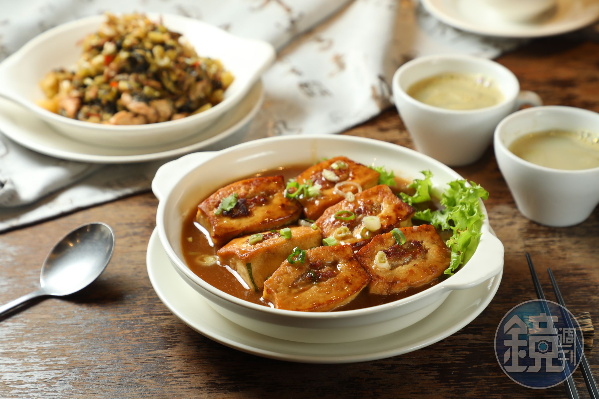 「炆釀豆腐」（前，300元／份）選用台南4號與高雄10號黃豆自製鹽滷豆腐，包入蝦皮、鹹魚與冬菜；「酸菜炒肉絲」（後，260元／份）也很下飯。