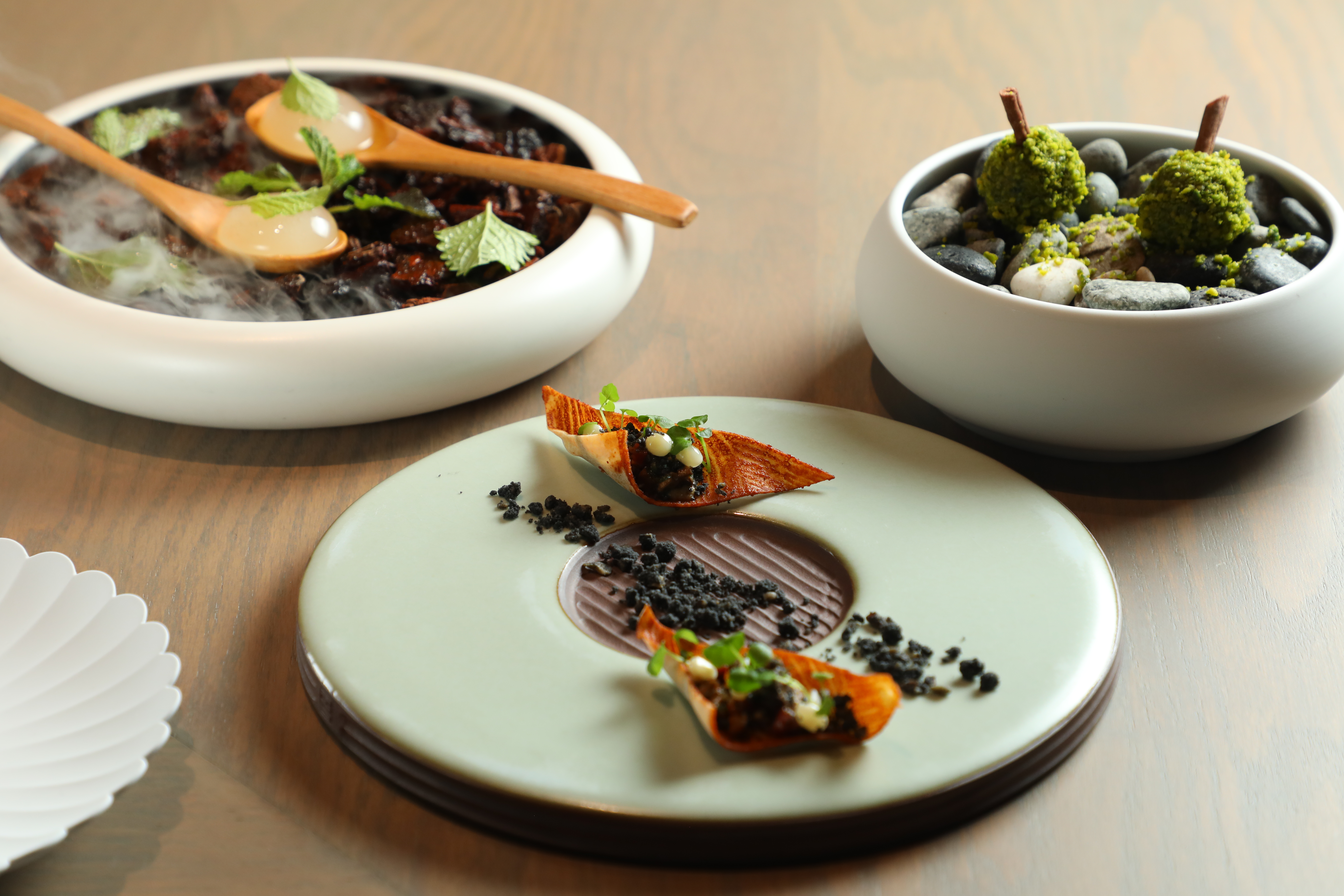 「君尹Brisé」7月推出的夏季新菜單以台灣盛夏森林的景致破題，以芭樂檸檬晶球、燻相臘肉、開心果乳酪棒，展開清晨至日暮的味覺旅程。（2,680元午餐菜色）