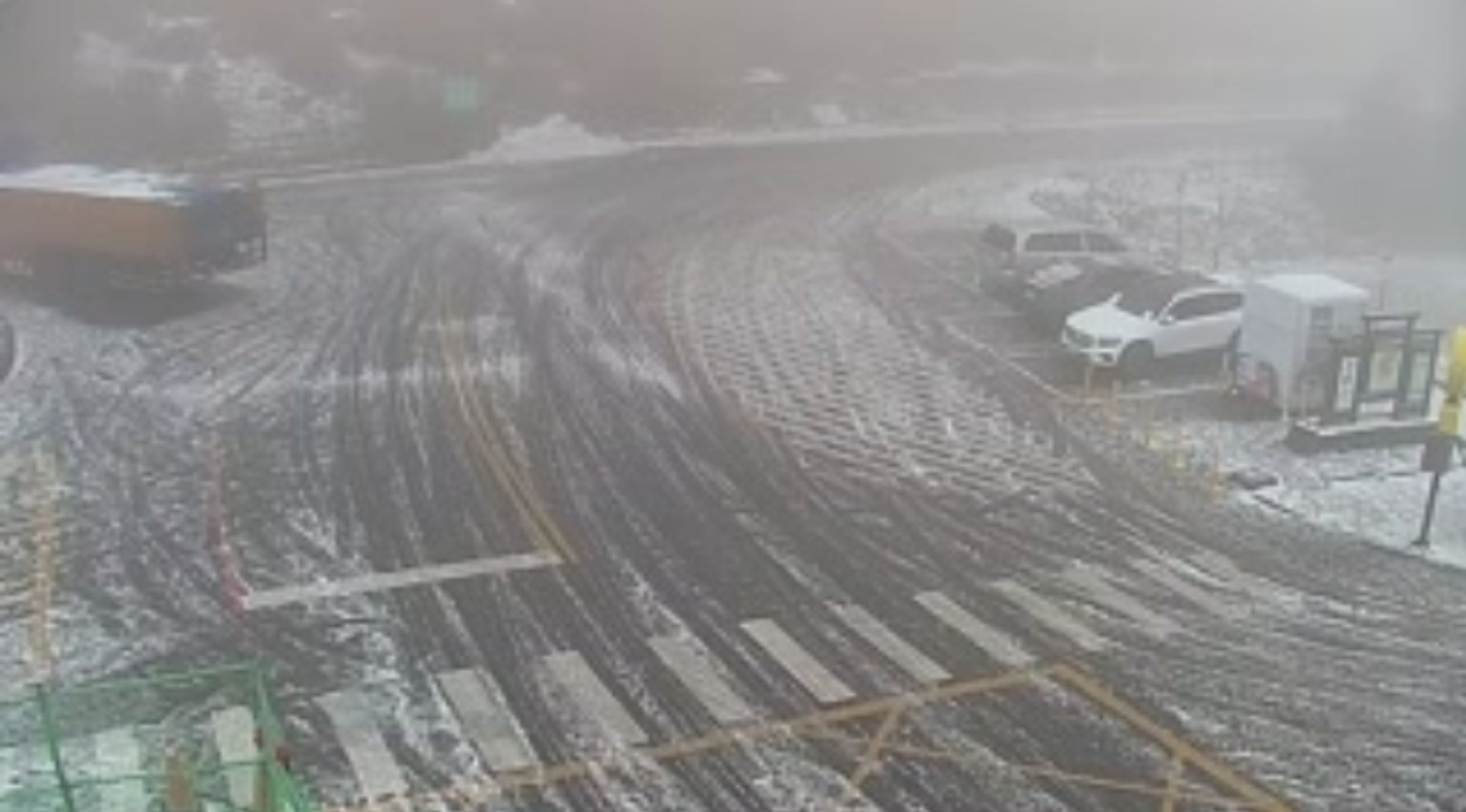 合歡山今日降冰霰,化身銀白世界,讓追雪族嗨翻了;圖為合歡山遊客服務中心。(翻攝自公路總局即時影像)