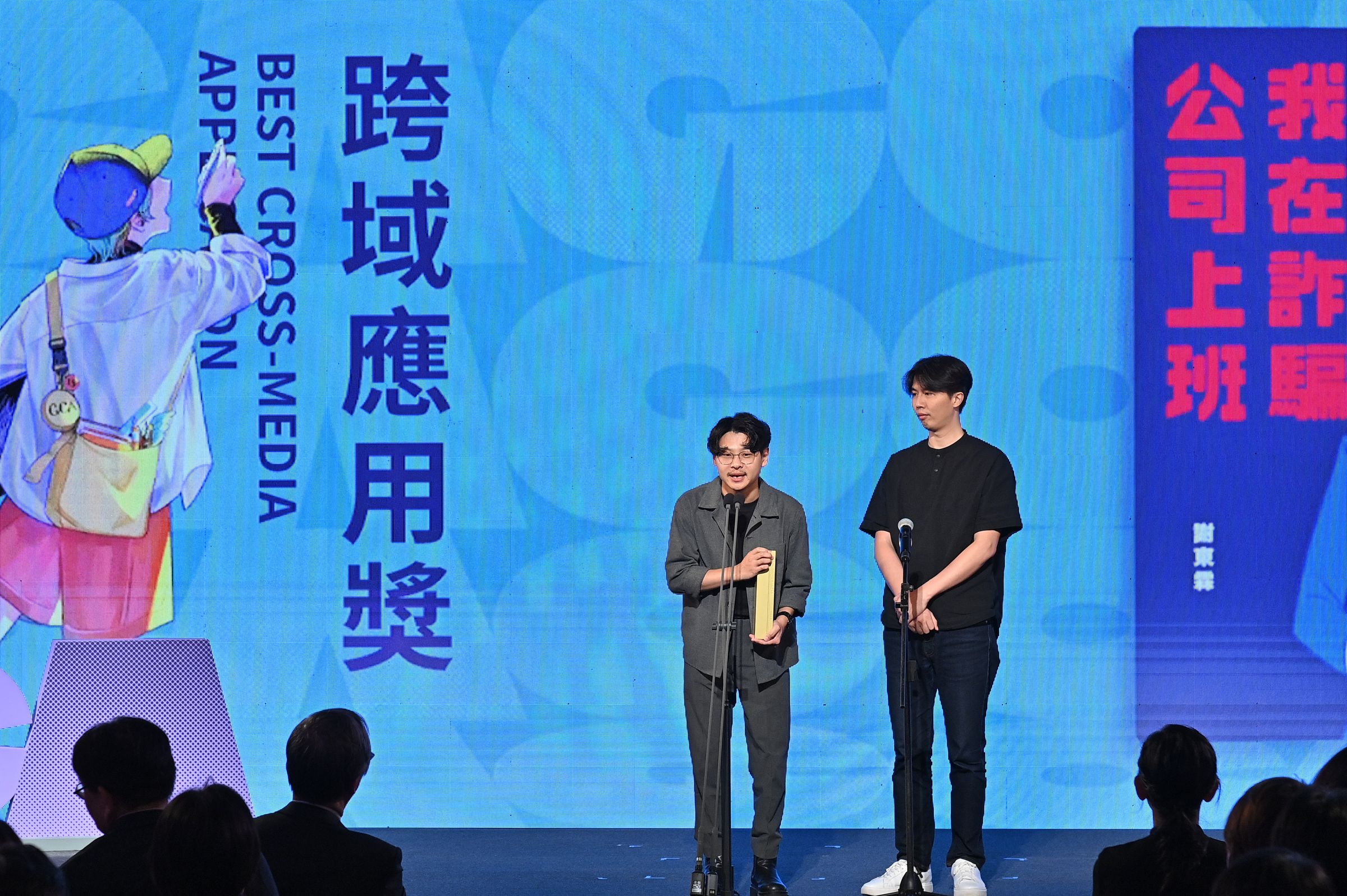 跨域應用獎由果陀劇場製作的《我在詐騙公司上班》音樂劇獲得,導演蘇昱瑋(左)與漫畫家謝東霖(右)上台領獎。