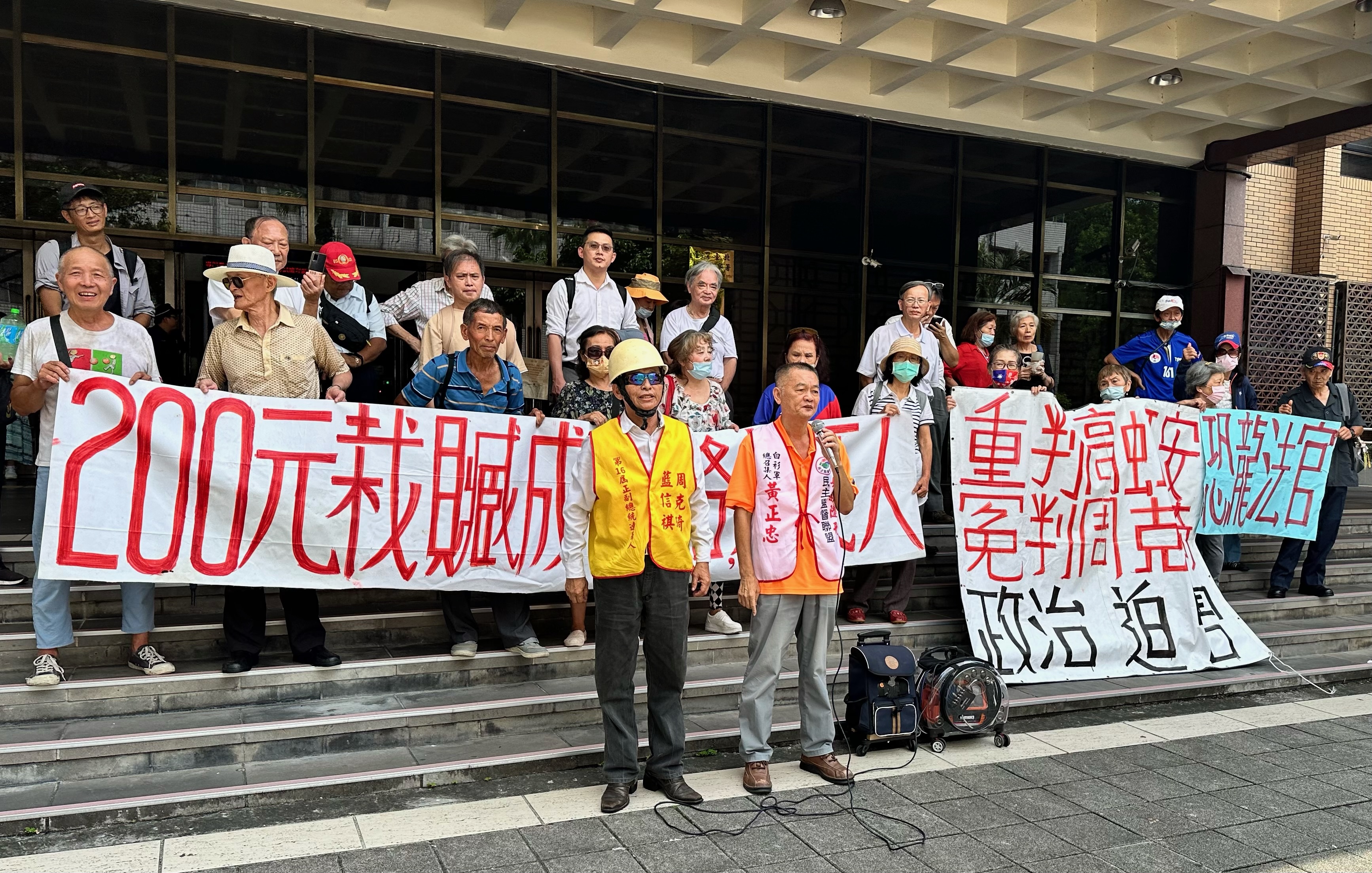 周克琦（前排左）與自稱「台灣皇帝」的藍信祺搭檔參與2023大選，今因賄選遭判3年後與支持者在法院前抗議。