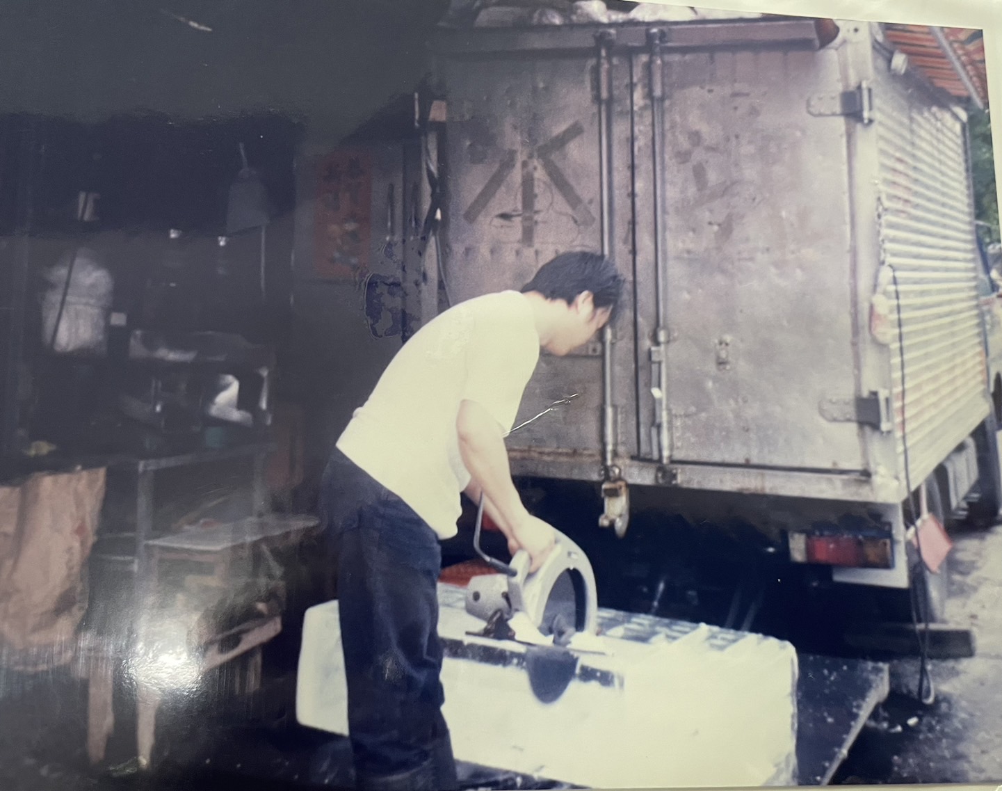 早年沒有食安概念,傳統冰塊業者都在地上就鋸大冰塊,鋸完客戶要的尺寸後,直接用機車送到店家。(林洲旭提供)