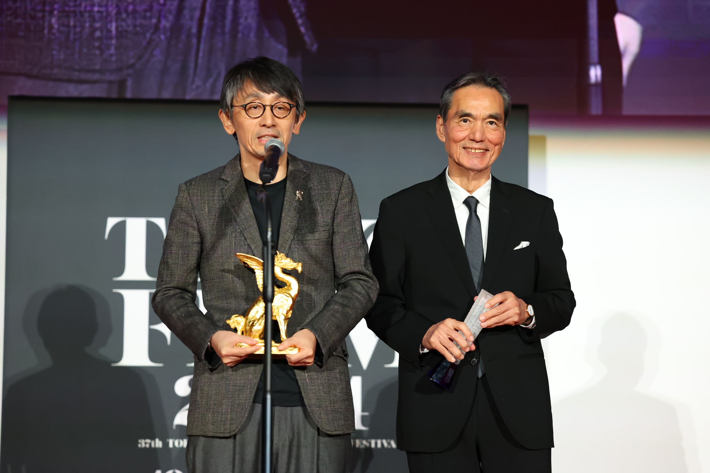 吉田大八（左）執導的《生之敵》在東京國際影展獲3項肯定，包含男主角長塚京三拿下最佳男主角殊榮。（東京國際影展提供）