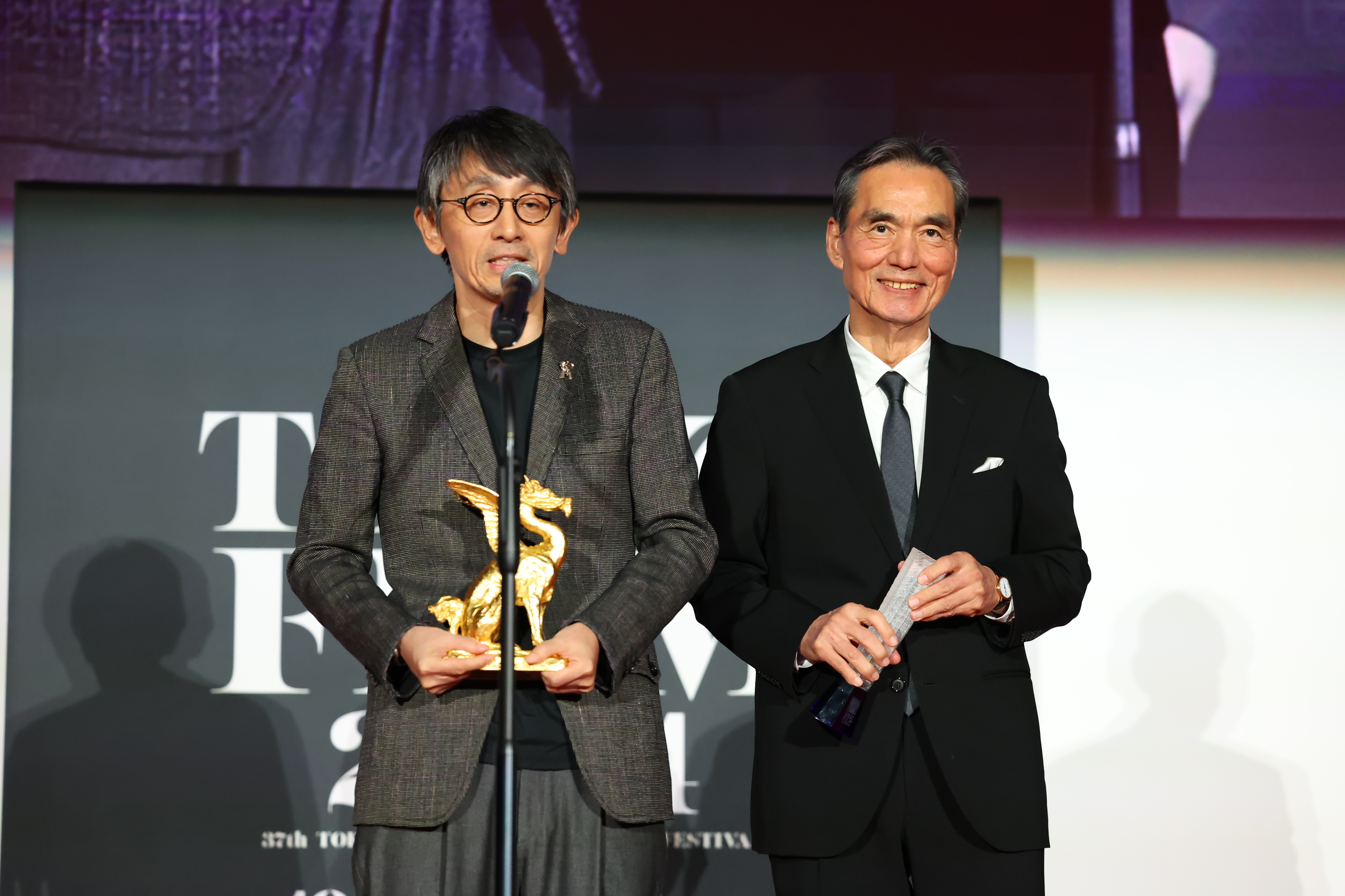 吉田大八（左）執導的《生之敵》在東京國際影展獲3項肯定，包含男主角長塚京三拿下最佳男主角殊榮。（東京國際影展提供）