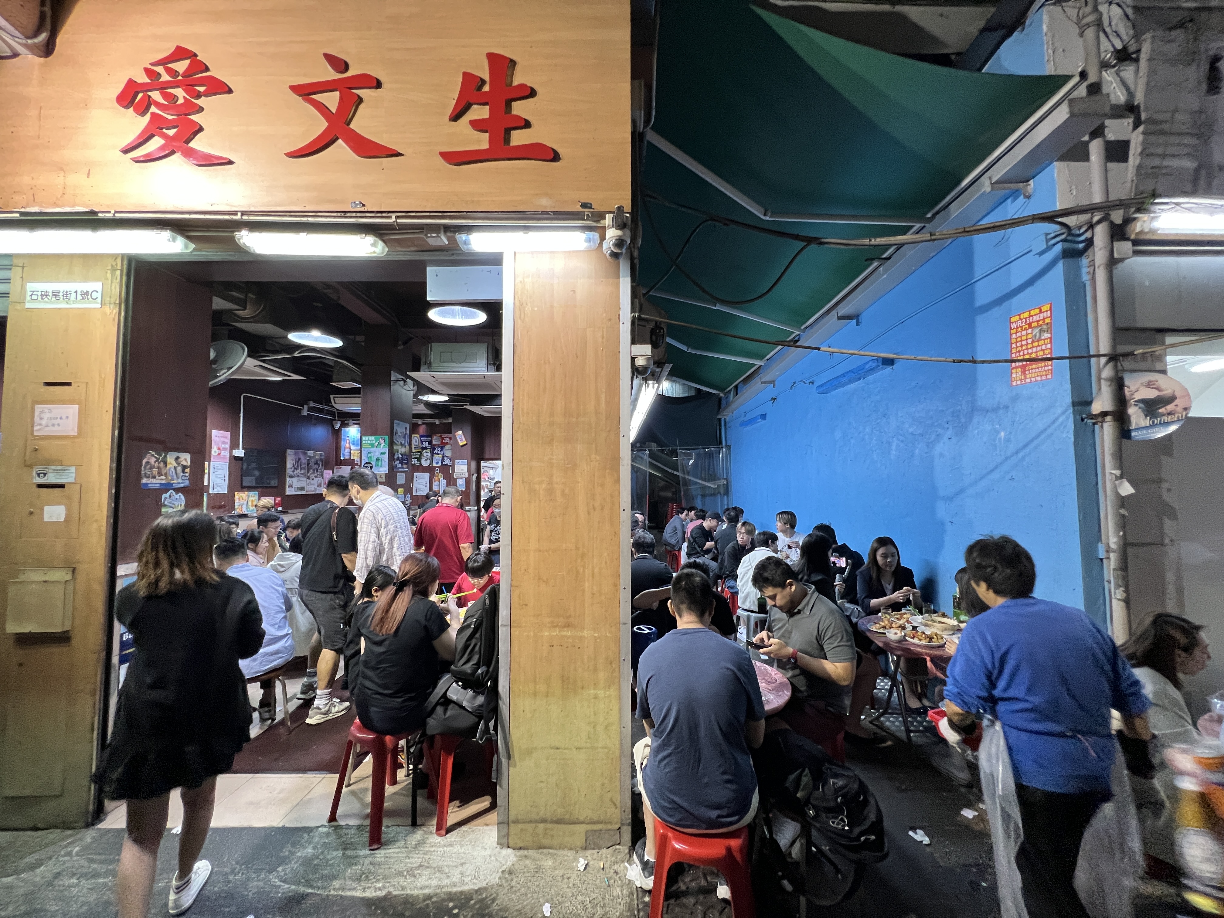 店面中間的小巷也擺上一整排桌子，熱鬧喧騰。