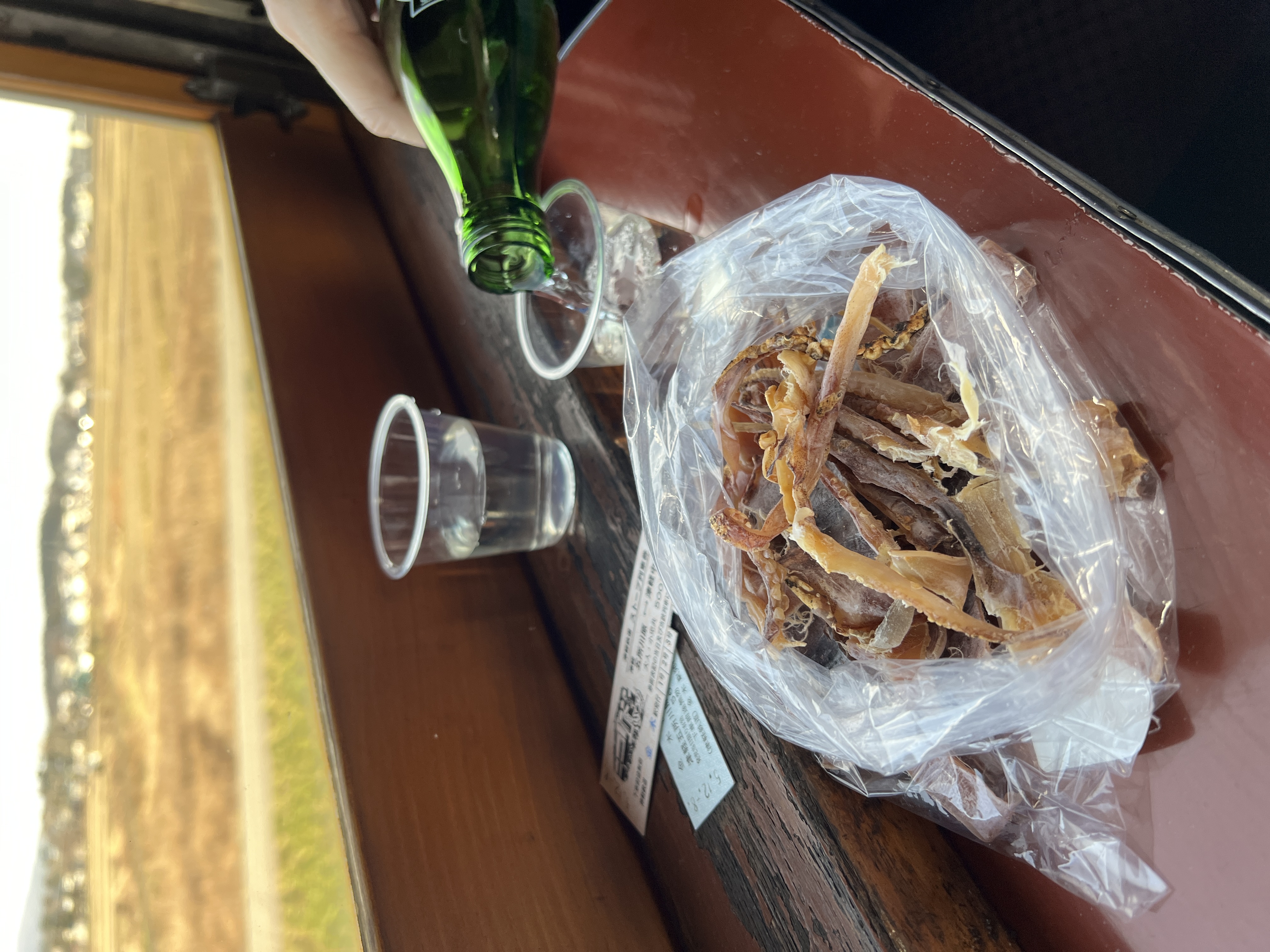 等列車員把魷魚撕成條狀,裝在塑膠袋裡,打開清酒就可開始享用。