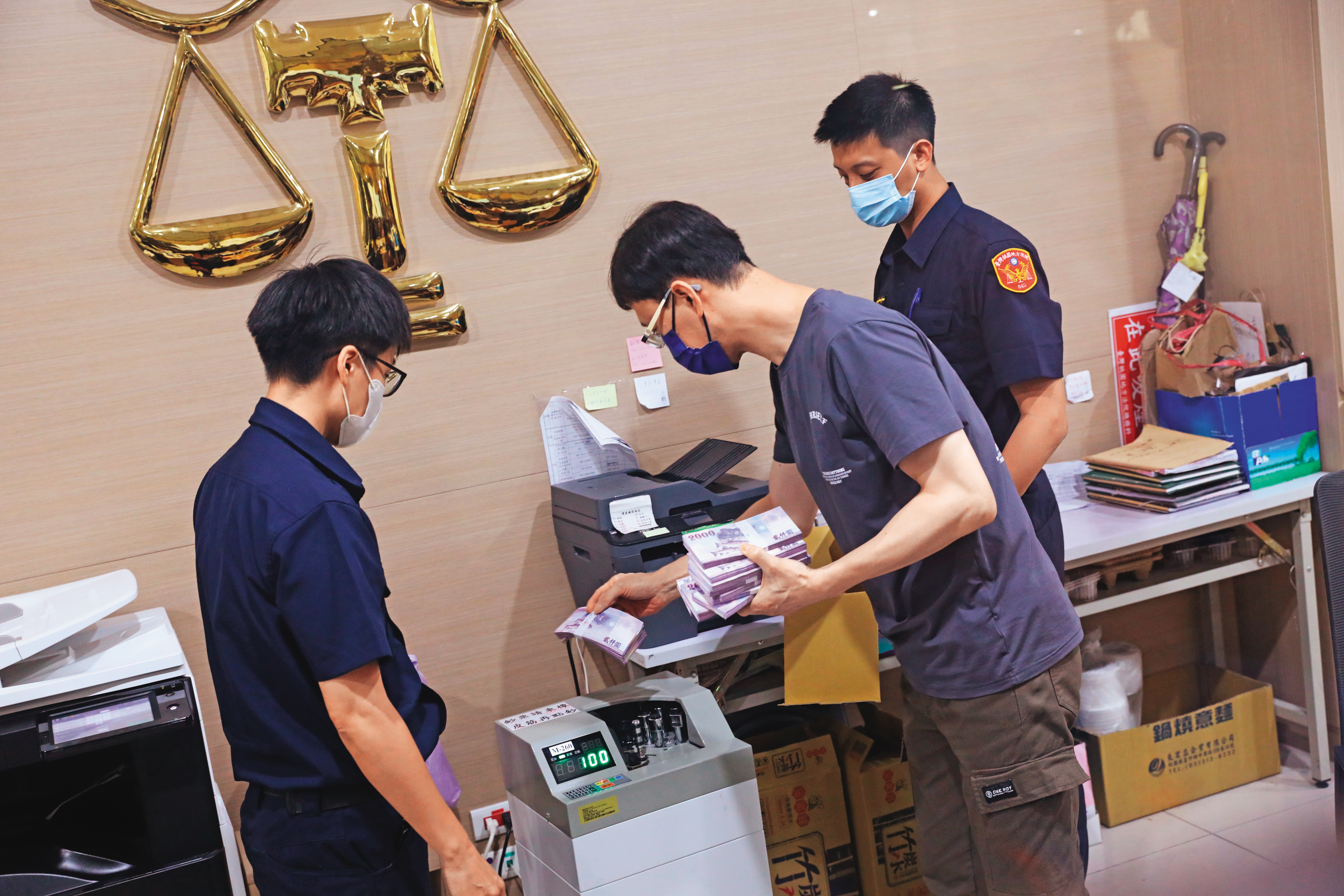 鄭文燦親友帶著500萬元前來法院辦保，由法警戒護協助點鈔作業。