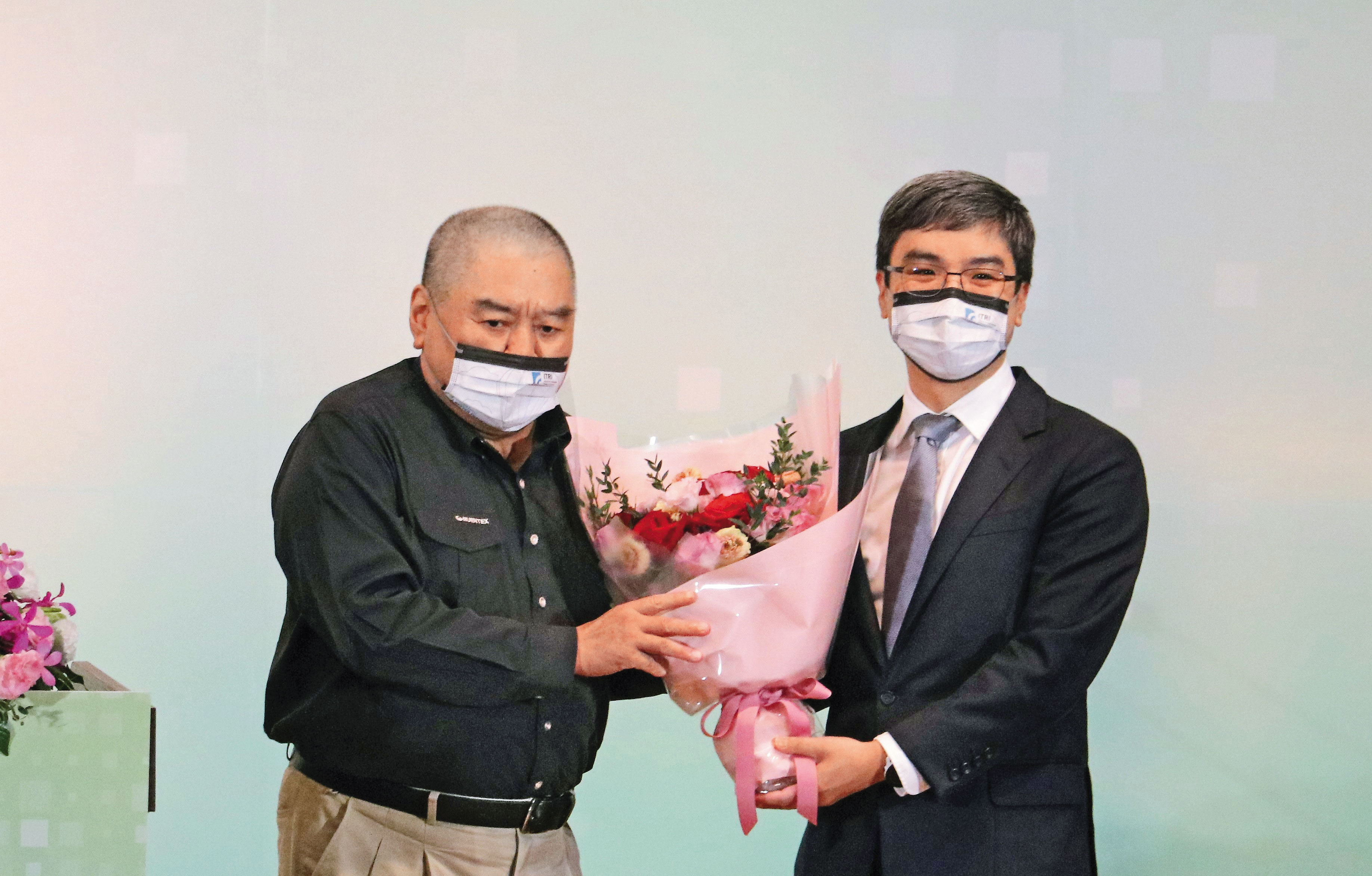 尹衍樑（左）獲選為工研院院士，由任職南山人壽董事長的兒子尹崇堯（右）獻花致意。（唐獎教育基金會提供）