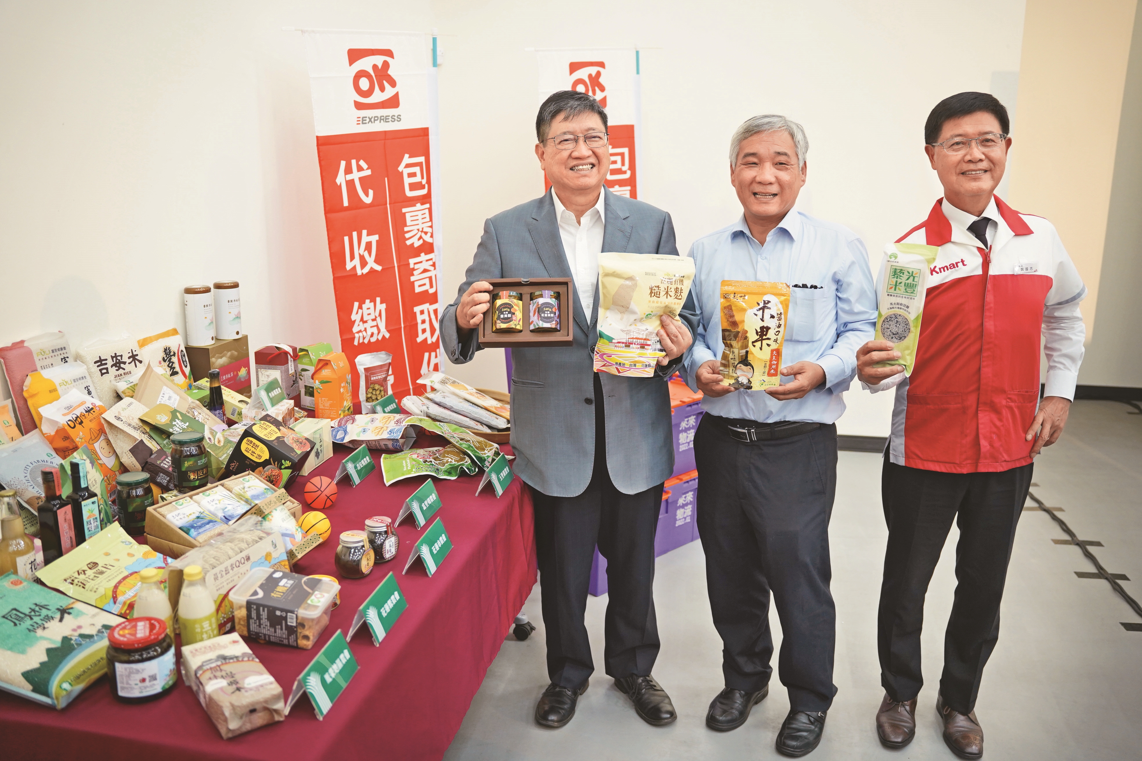 楊縣長（左起）、農業部司長陳俊言及OK超商總經理魏國志，在農產品店到店物流系統啓動記者會上宣傳竹縣及花蓮農特產。（新竹縣政府提供）