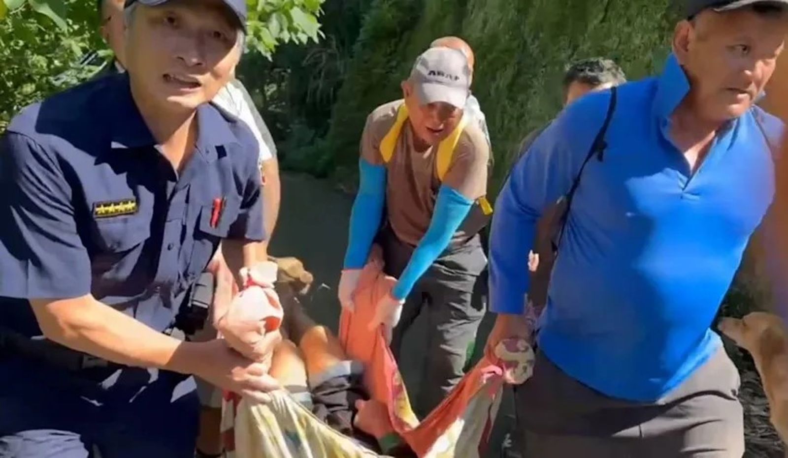 搜救人員與村民合力將虛弱的松姓男子抬出山溝。（翻攝畫面）