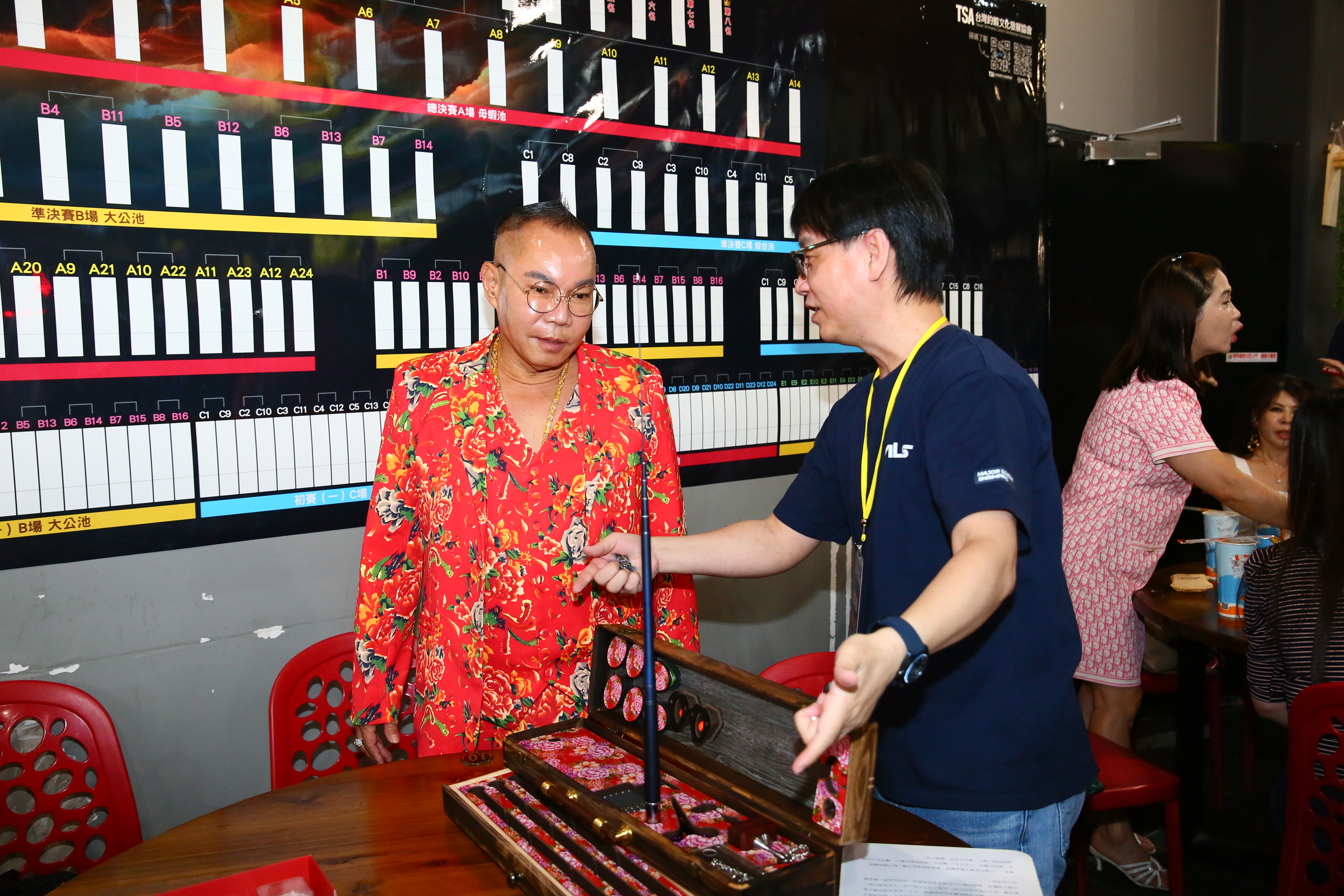 釣蝦文化發展協會理事長張林裕(右)邀請吊車大王胡漢龑(左)為「第二屆「MLS國際釣蝦競技邀請賽」擔任代言人,他用胡漢龑最愛的東北大花打造一組槍箱作為贈禮。