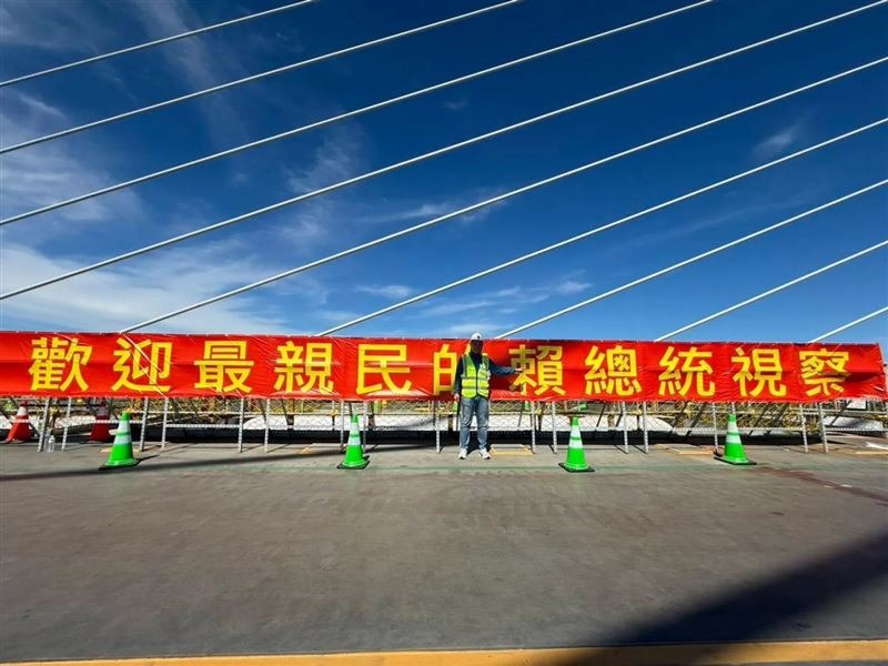 地標「淡江大橋」今（16日）舉辦合龍儀式，活動現場出現至少3面「歡迎最親民的賴總統視察」的紅布條。（翻攝自陳偉杰threads）