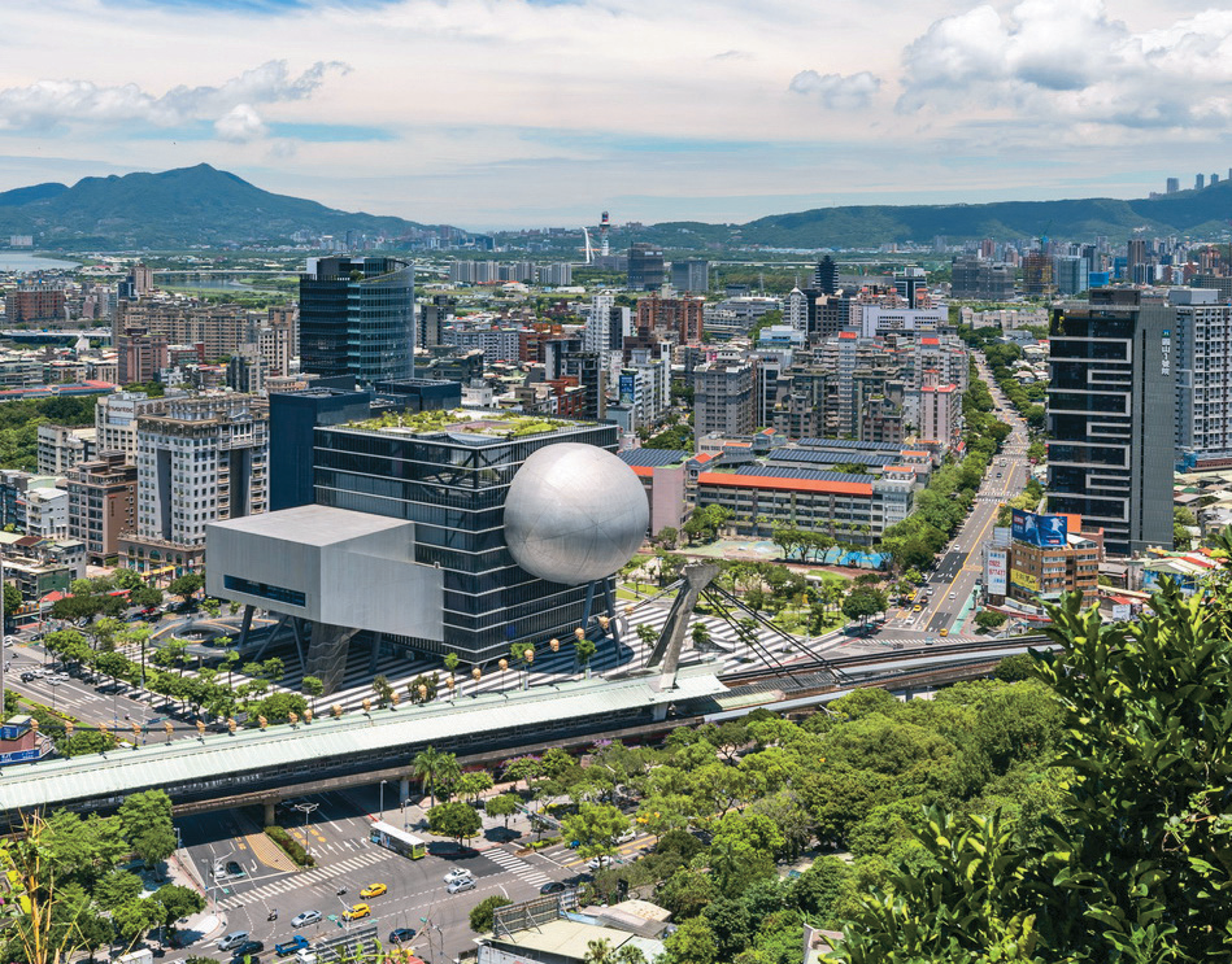 台北表演藝術中心的銀白色球體造型，飄浮於繁鬧市井中，與周邊形成強烈對比。（圖／台北市觀光傳播局）