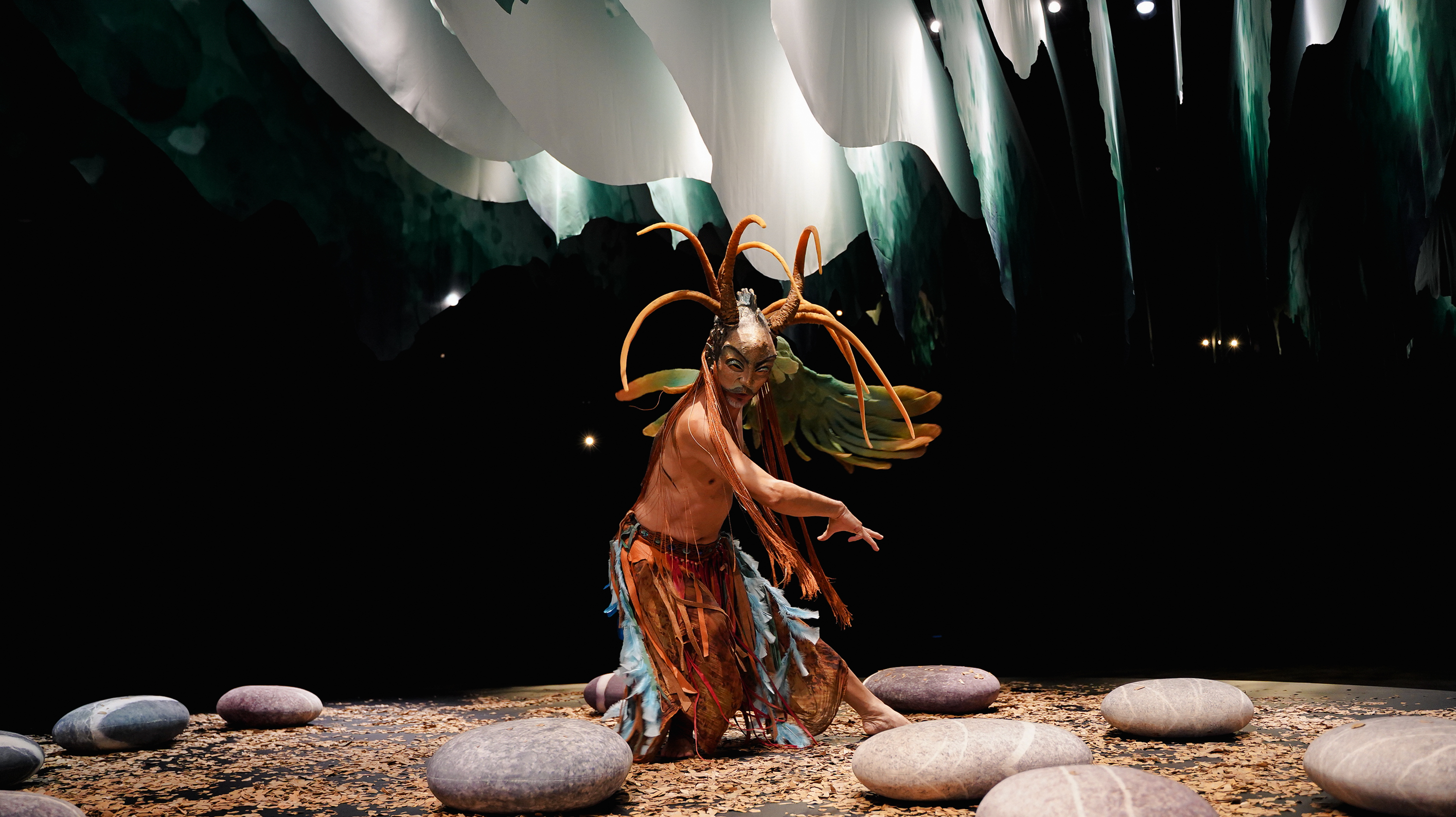 張忘戴著混合羊頭與魚頭的面具，左手是大鳥的羽翼，化身他想像的古老玄鳥，宛如大自然的信使飛到人間，就像引路者一般，帶領觀眾穿越迷霧。（世界宗教博物館提供）