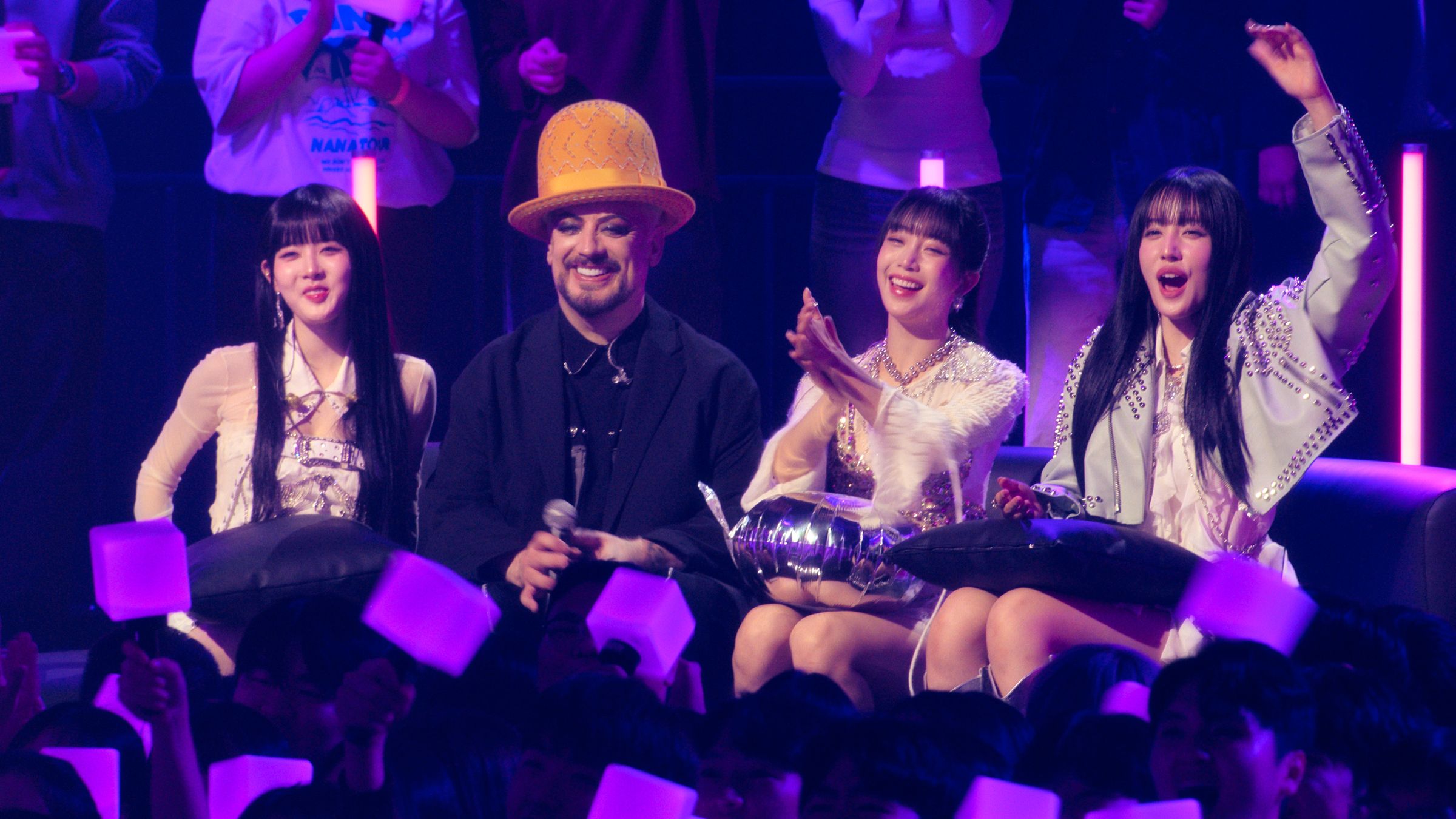 喬治男孩（左2）與韓團STAYC一起欣賞其他歌手的表演。（Apple TV+提供）