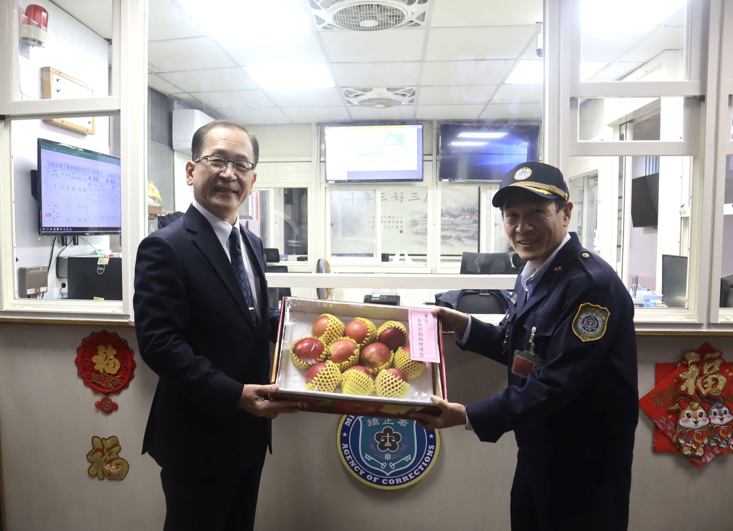 矯正署長林憲銘(左)送上蘋果禮盒,象徵平平安安。(矯正署提供)