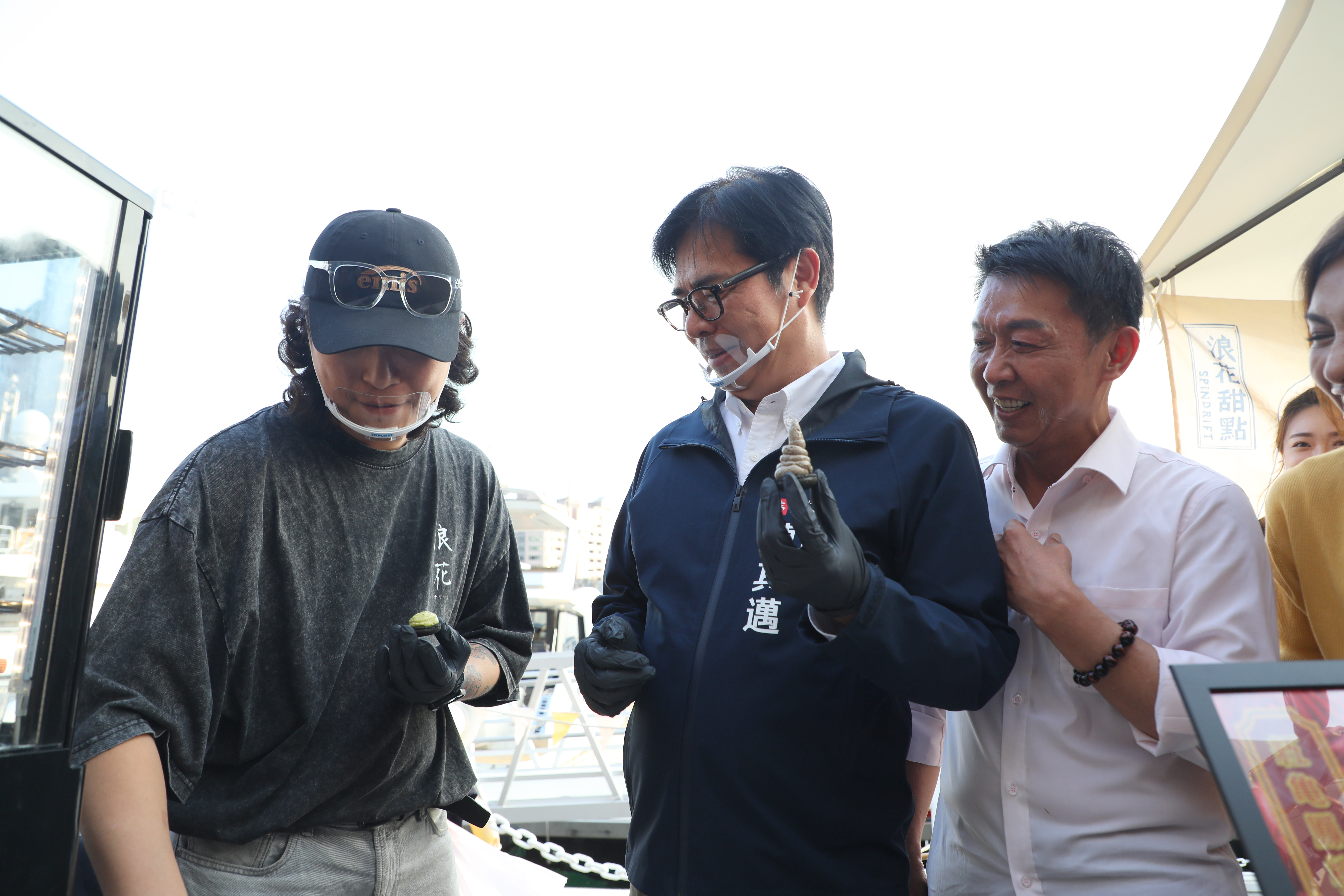 市長陳其邁走訪青創店家浪花甜點攤位體驗馬卡龍如何組裝。