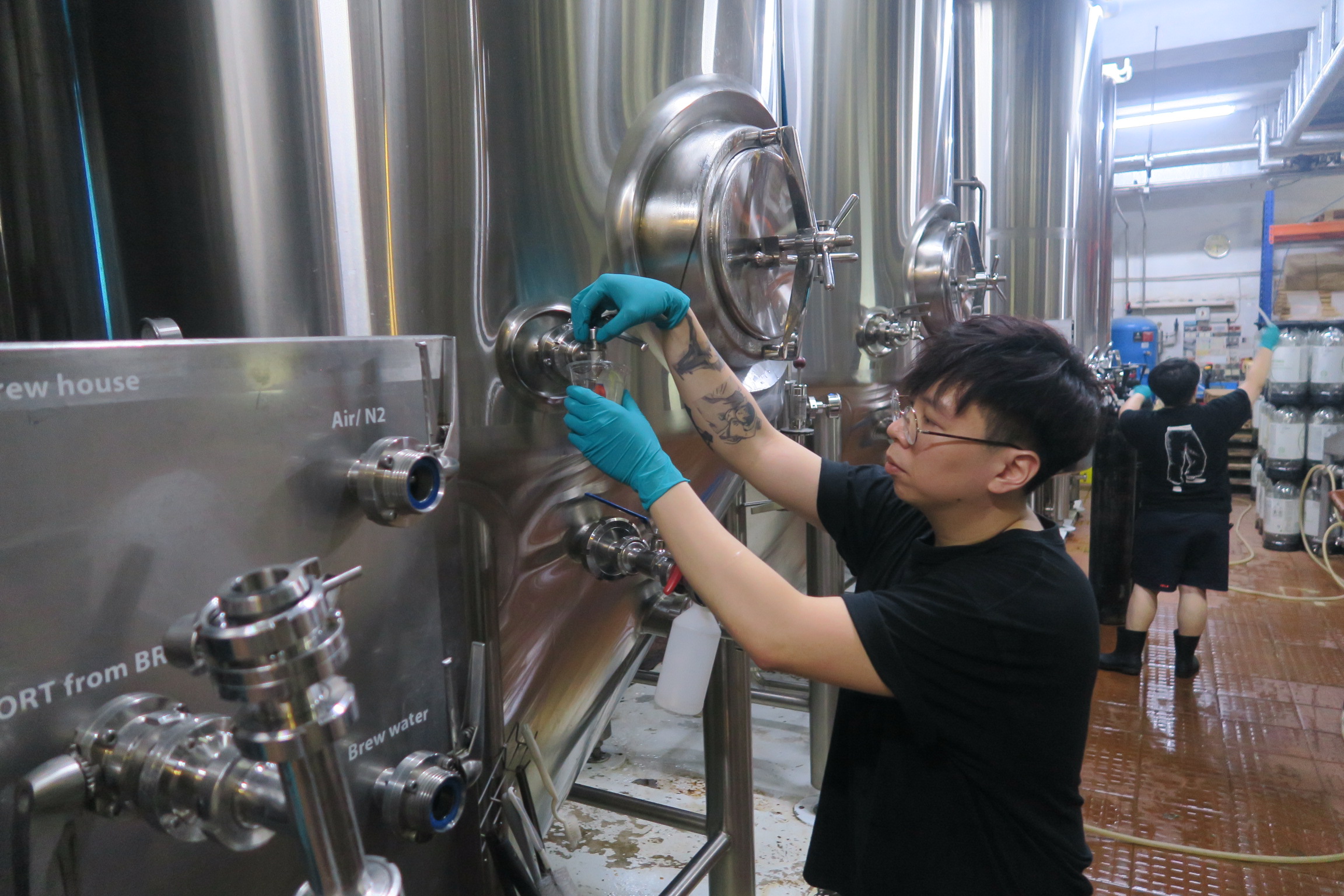 釀酒師盧建培(Harry Loo)汲取剛釀好的啤酒給我們品嘗。