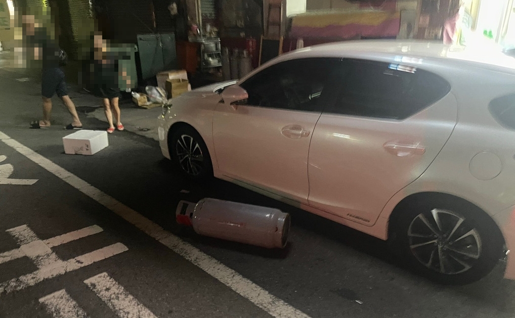 台中一名男子深夜扛瓦斯桶砸車，隨後又衝進超商刺傷路人。（翻攝畫面）