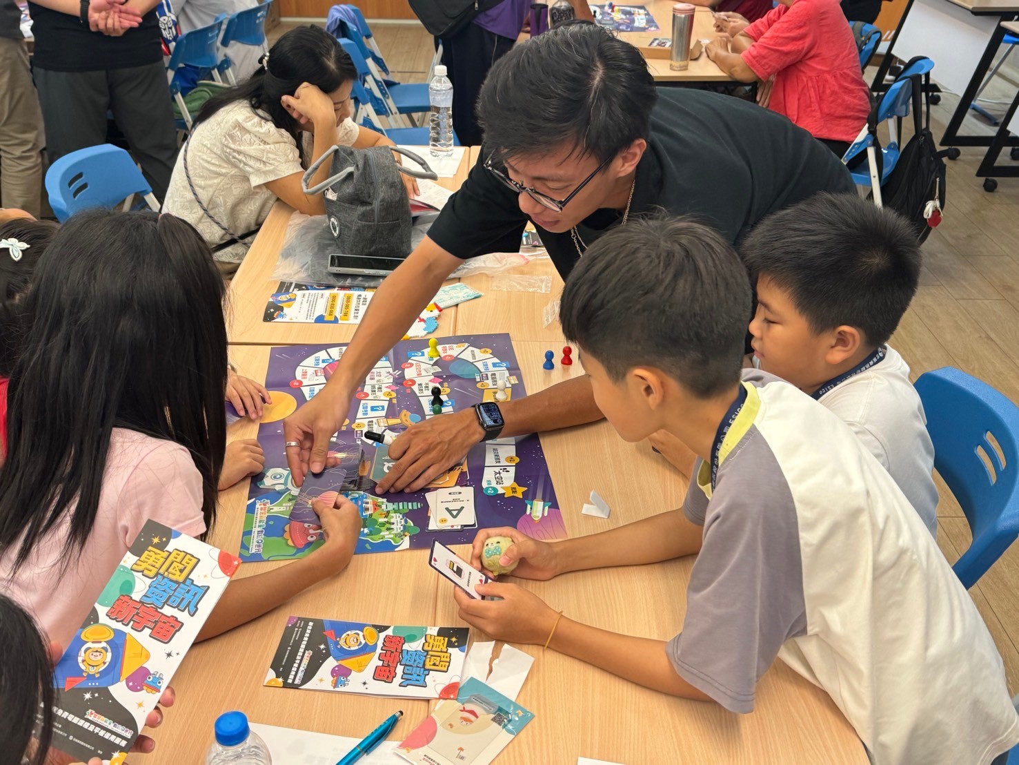 新住民及其子女一起遊玩移民署製作的錦囊「資訊銀河冒險」桌遊。（移民署提供）