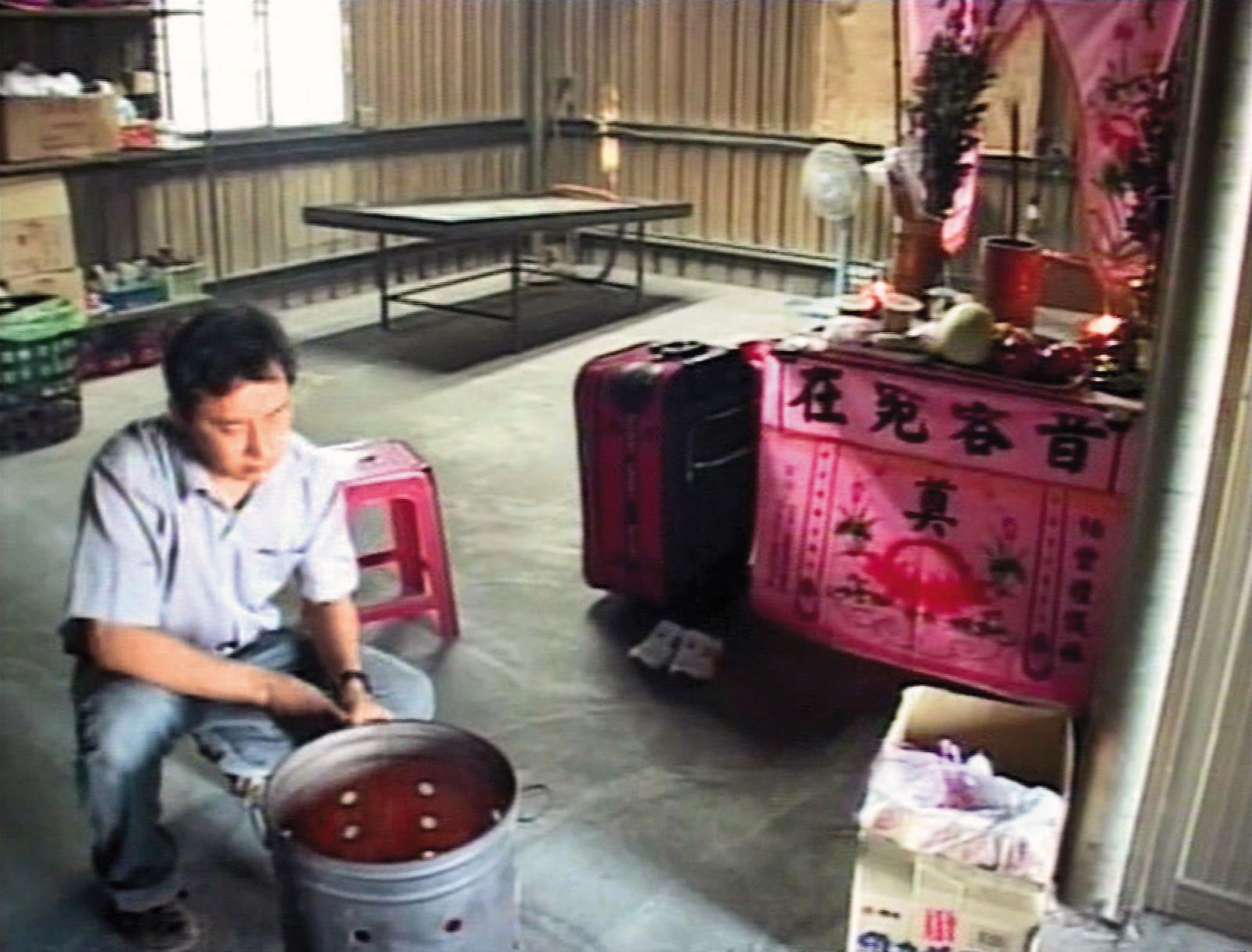 李雙全在鏡頭前為妻子陳氏紅琛守靈燒紙錢，被檢警懷疑涉案後，留下遺書自縊身亡。（東森新聞提供）