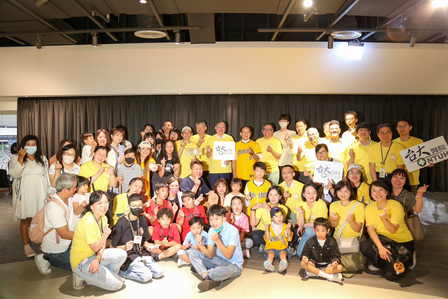 中信育樂董事長陳國恩（後排圖中右側）與台大醫護人員、兒童病患及家屬，一起觀賽替兄弟應援。（中信育樂提供）